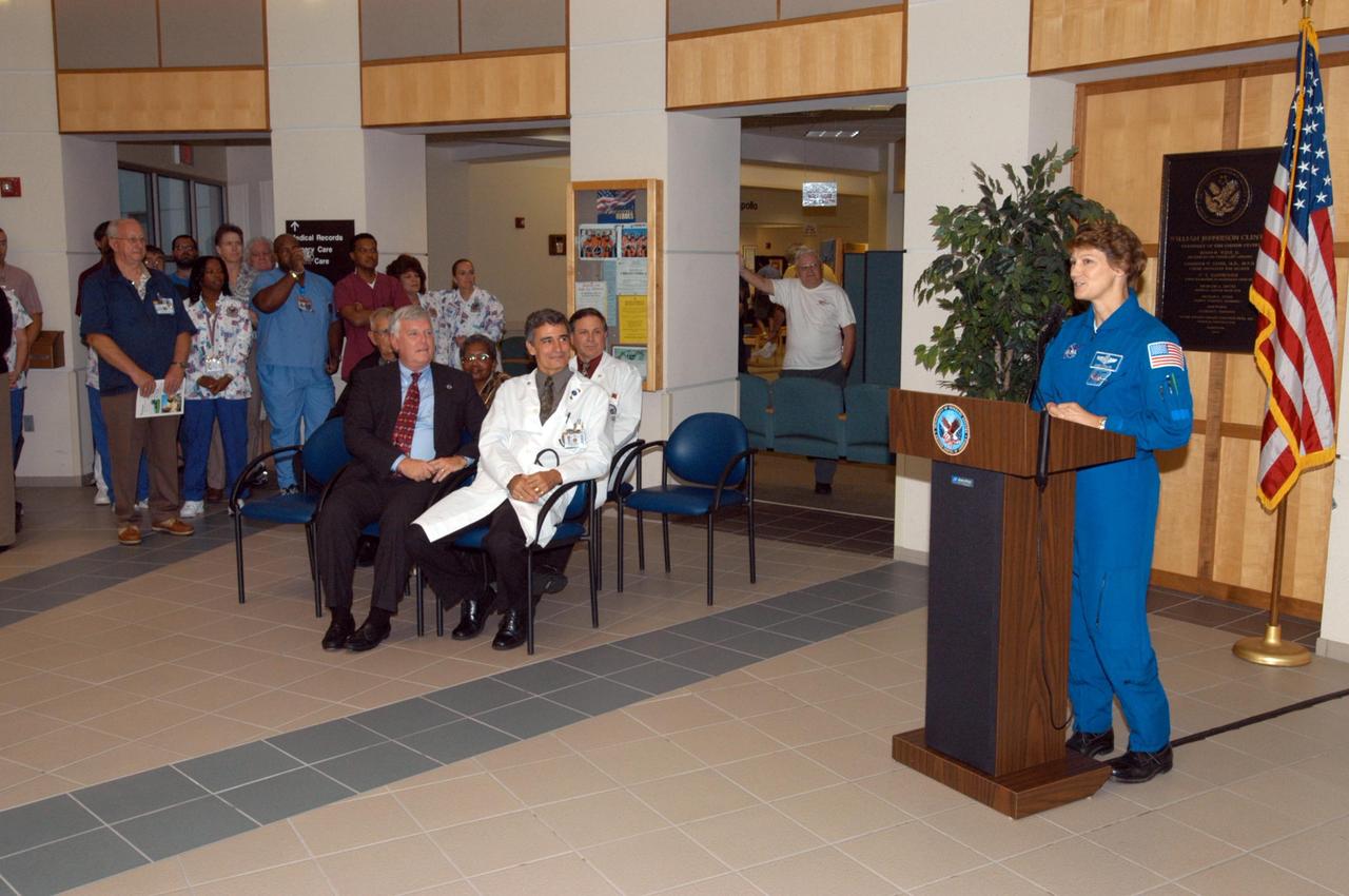 KENNEDY SPACE CENTER, FLA. -   STS-114 Mission Commander Eileen Collins speaks to guests during the dedication of a hospital wing at the V.A. Outpatient Clinic in Viera, Fla., in honor of space shuttle Discovery, to be known as the Discovery wing.  Joining in the dedication are, seated at left, Center Director Jim Kennedy and Dr. Thomas Howard who is chief medical officer of the clinic. Collins and her crew have returned to Florida especially for a celebration in the KSC Visitor Complex of the successful return to flight mission that launched July 26 of this year.