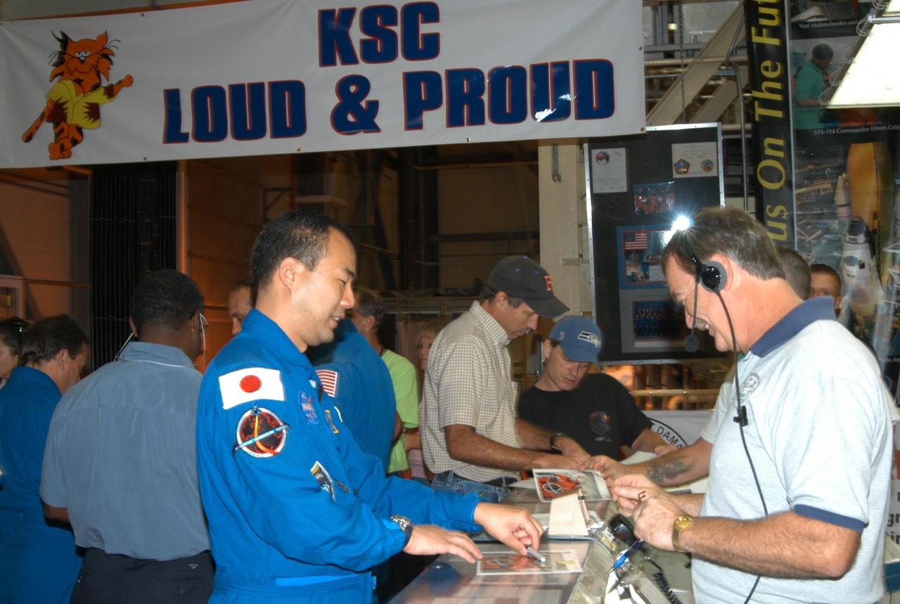 KENNEDY SPACE CENTER, FLA. - In Kennedy Space Center’s Orbiter Processing Facility Bay 3, STS-114 Mission Specialist Soichi Noguchi autographs photos for employees. He and other crew members are visiting several sites during their return to KSC. They have returned to Florida especially for a celebration in the KSC Visitor Complex of the successful return to flight mission that launched July 26 of this year.