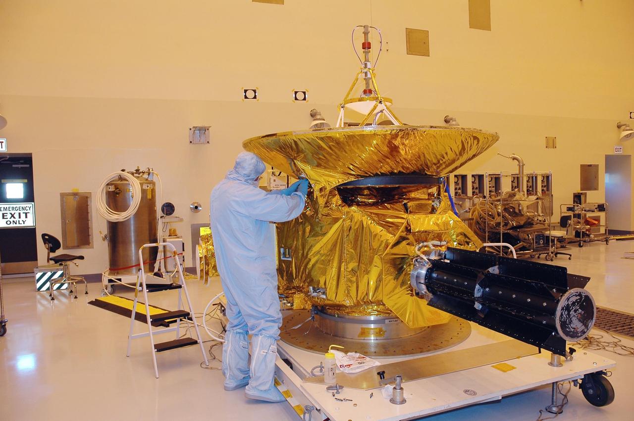 KENNEDY SPACE CENTER, FLA. - At NASA Kennedy Space Center’s Payload Hazardous Servicing Facility, a technician from the Applied Physics Laboratory adjusts part of the blanket that it is being installed as a heat shield around the New Horizons spacecraft. Carrying seven scientific instruments, the compact 1,060-pound New Horizons probe will characterize the global geology and geomorphology of Pluto and its moon Charon, map their surface compositions and temperatures, and examine Pluto's complex atmosphere. After that, flybys of Kuiper Belt objects from even farther in the solar system may be undertaken in an extended mission. New Horizons is the first mission in NASA's New Frontiers program of medium-class planetary missions. The spacecraft, designed for NASA by the Johns Hopkins University Applied Physics Laboratory in Laurel, Md., will fly by Pluto and Charon as early as summer 2015.