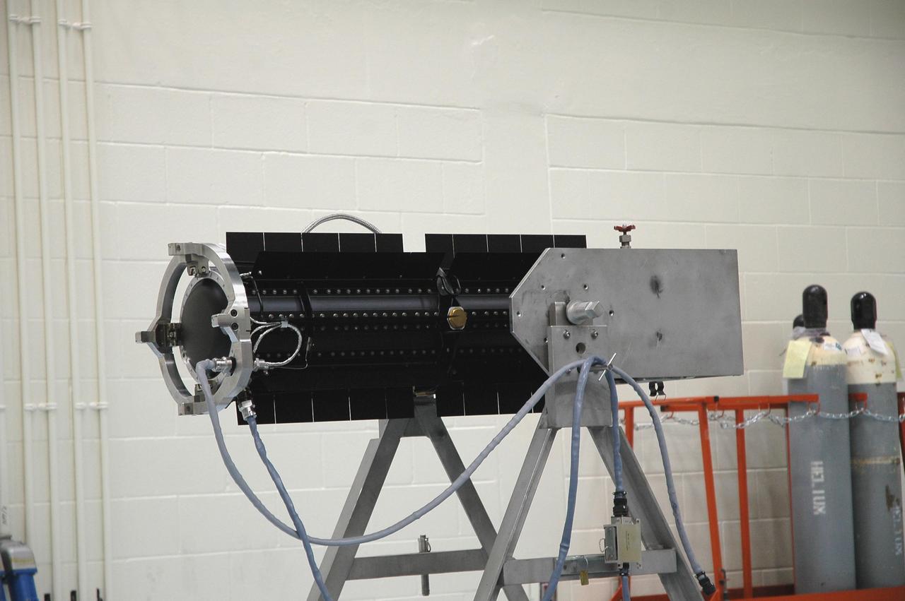 KENNEDY SPACE CENTER, FLA. - In the RTG Facility at Kennedy Space Center, the radioisotope thermoelectric generator (RTG) rests in a horizontal position. The RTG is the baseline power supply for the NASA’s New Horizons spacecraft, scheduled to launch in January 2006 on a journey to Pluto and its moon, Charon. As it approaches Pluto, the spacecraft will look for ultraviolet emission from Pluto's atmosphere and make the best global maps of Pluto and Charon in green, blue, red and a special wavelength that is sensitive to methane frost on the surface. It will also take spectral maps in the near infrared, telling the science team about Pluto's and Charon's surface compositions and locations and temperatures of these materials. When the spacecraft is closest to Pluto or its moon, it will take close-up pictures in both visible and near-infrared wavelengths. It is expected to reach Pluto in July 2015.