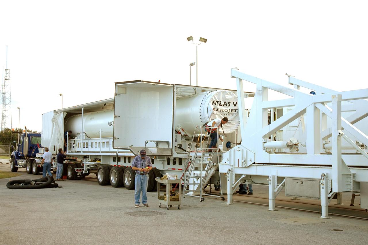 KENNEDY SPACE CENTER, FLA. - A transport trailer carrying a solid rocket booster is opened up after arriving at the Vertical Integration Facility on Launch Complex 41 at Cape Canaveral Air Force Station in Florida. The booster rocket will be mated, along with others, to the Atlas V already in the VIF. The Atlas V is the launch vehicle for NASA’s New Horizons spacecraft, scheduled to launch in January 2006 on a journey to Pluto and its moon, Charon.