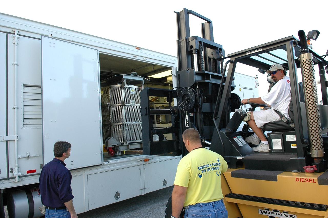 KENNEDY SPACE CENTER, FLA. - In NASA Kennedy Space Center’s Payload Hazardous Servicing Facility, Boeing workers garbed in clean room suits get ready to move the third stage, or upper stage, for the New Horizons spacecraft.  The third stage is a Boeing STAR 48 solid-propellant kick motor.  The launch vehicle for New Horizons is the Atlas V rocket, scheduled to launch from Cape Canaveral Air Force Station, Fla., during a 35-day window that opens Jan. 11, and fly through the Pluto system as early as summer 2015.