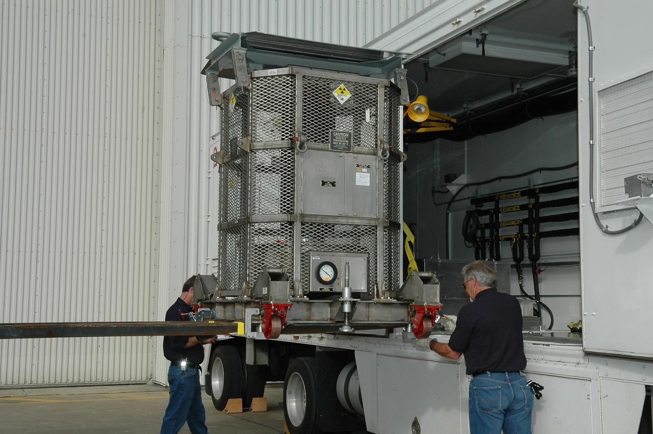 KENNEDY SPACE CENTER, FLA. - At NASA Kennedy Space Center’s Payload Hazardous Servicing Facility, the radioisotope thermoelectric generator (RTG) is removed from the transporter. Inside the facility, it will be installed in the New Horizons spacecraft for a fit check. The RTG is the baseline power supply for New Horizons, scheduled to launch in January 2006 on a journey to Pluto and its moon, Charon. It is expected to reach Pluto in July 2015.