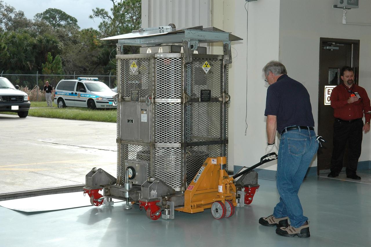 KENNEDY SPACE CENTER, FLA. - At NASA Kennedy Space Center’s Payload Hazardous Servicing Facility, the radioisotope thermoelectric generator (RTG) is rolled into the building. Inside the facility, it will be installed in the New Horizons spacecraft for a fit check. The RTG is the baseline power supply for New Horizons, scheduled to launch in January 2006 on a journey to Pluto and its moon, Charon. It is expected to reach Pluto in July 2015.