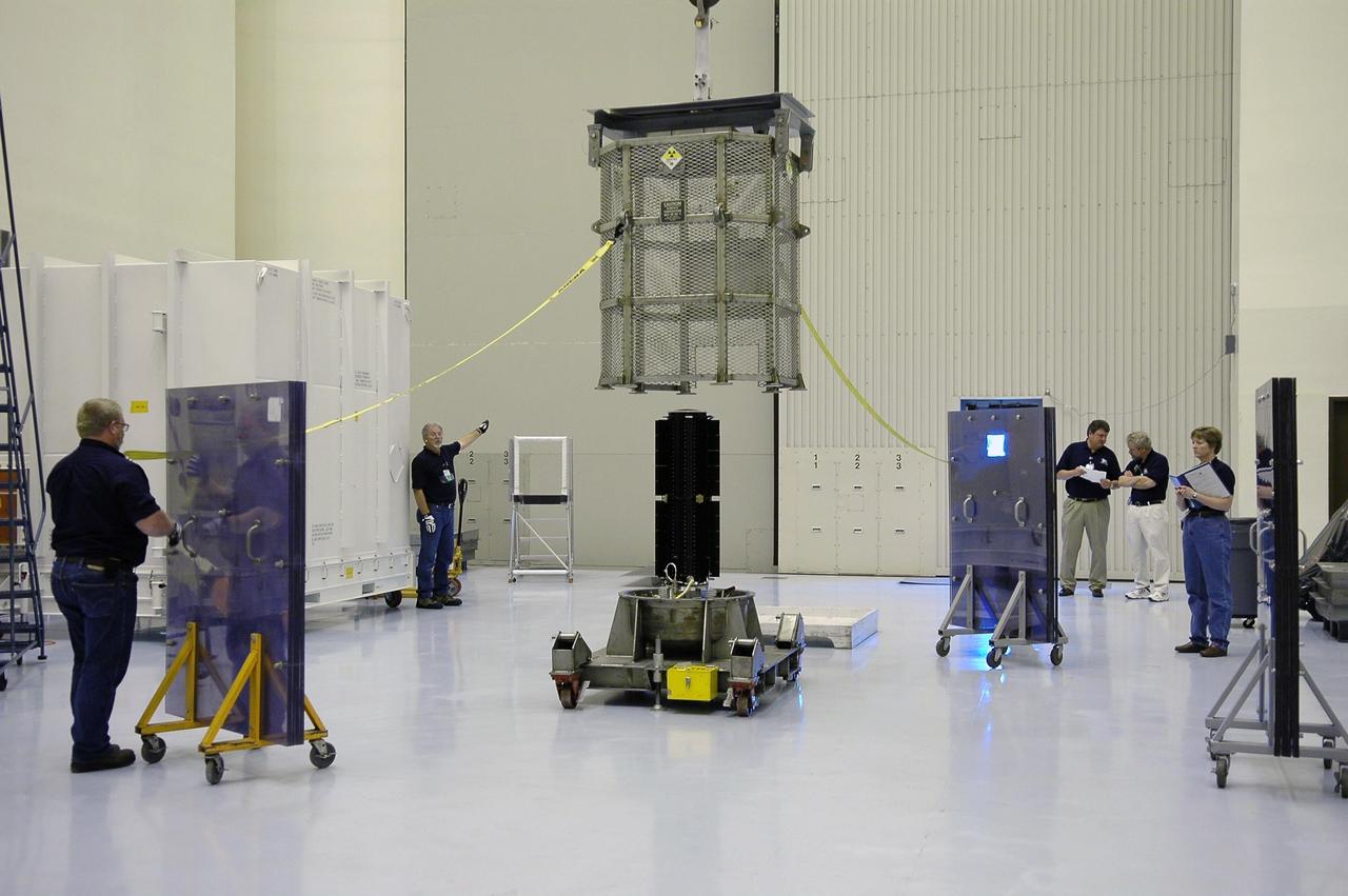 KENNEDY SPACE CENTER, FLA. - In NASA Kennedy Space Center’s Payload Hazardous Servicing Facility, the metal canister is lifted away from the radioisotope thermoelectric generator (RTG). Inside the facility, the RTG will be installed in the New Horizons spacecraft for a fit check. The RTG is the baseline power supply for New Horizons, scheduled to launch in January 2006 on a journey to Pluto and its moon, Charon. It is expected to reach Pluto in July 2015.