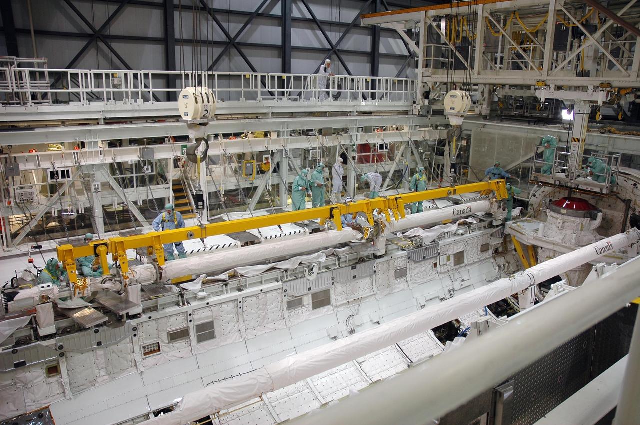 KENNEDY SPACE CENTER, FLA. -In the Orbiter Processing Facility Bay 1 at NASA Kennedy Space Center, a crane is attached to the remote manipulator system boom in Atlantis’ payload bay.  The boom is being removed from Atlantis and will be temporarily stored. The RMS includes the electromechanical arm that maneuvers a payload from the payload bay of the orbiter to its deployment position and then releases it. It can also grapple a free-flying payload, maneuver it to the payload bay of the orbiter and berth it in the orbiter. The RMS arm is 50 feet 3 inches long and 15 inches in diameter. It weighs 905 pounds, and the total system weighs 994 pounds. The RMS has six joints that correspond roughly to the joints of the human arm, with shoulder yaw and pitch joints; an elbow pitch joint; and wrist pitch, yaw and roll joints. The end effector is the unit at the end of the wrist that actually grabs, or grapples, the payload.