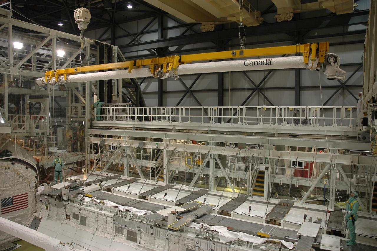 KENNEDY SPACE CENTER, FLA. - In the Orbiter Processing Facility Bay 1 at NASA Kennedy Space Center, a crane lifts the remote manipulator system boom out of Atlantis’ payload bay.  The boom will be temporarily stored.  The RMS includes the electromechanical arm that maneuvers a payload from the payload bay of the orbiter to its deployment position and then releases it. It can also grapple a free-flying payload, maneuver it to the payload bay of the orbiter and berth it in the orbiter. The RMS arm is 50 feet 3 inches long and 15 inches in diameter. It weighs 905 pounds, and the total system weighs 994 pounds. The RMS has six joints that correspond roughly to the joints of the human arm, with shoulder yaw and pitch joints; an elbow pitch joint; and wrist pitch, yaw and roll joints. The end effector is the unit at the end of the wrist that actually grabs, or grapples, the payload.