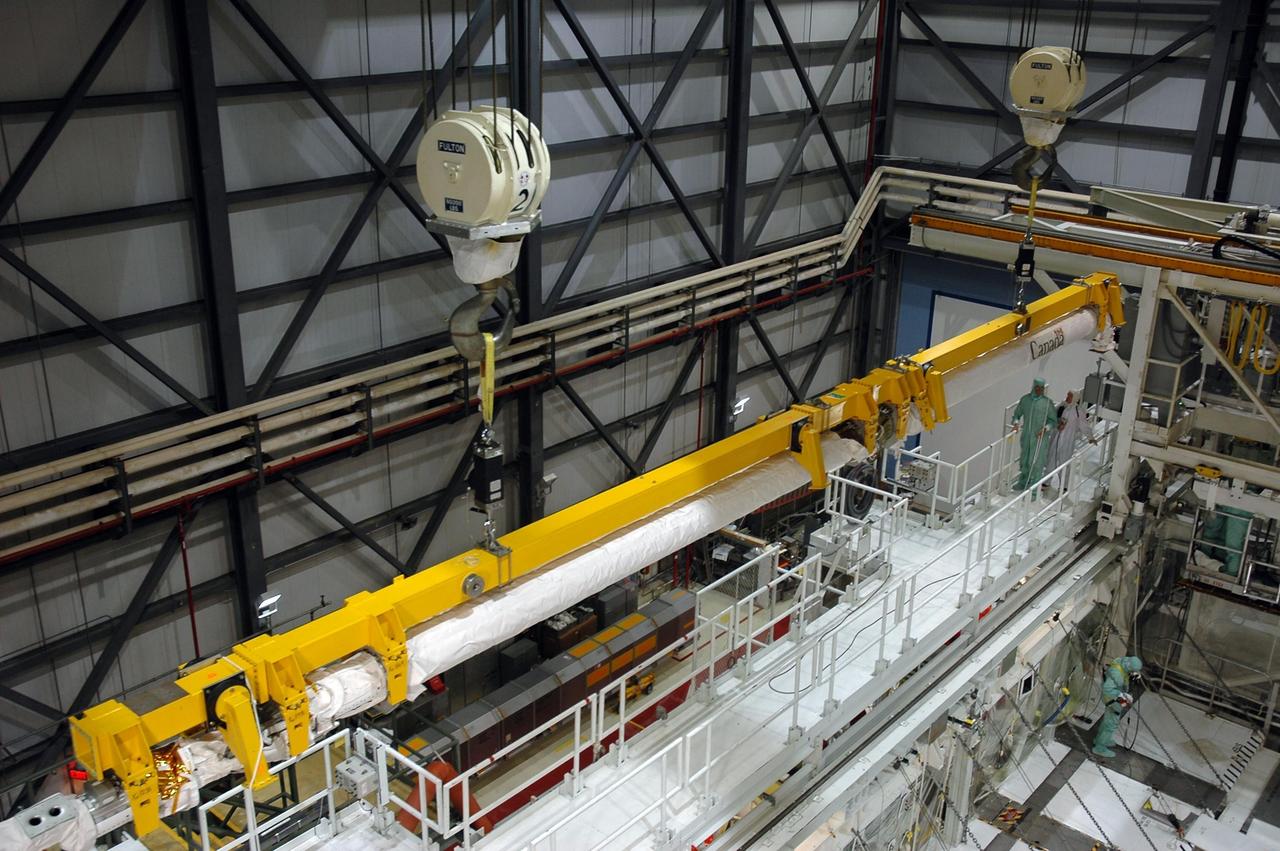 KENNEDY SPACE CENTER, FLA. - In the Orbiter Processing Facility Bay 1 at NASA Kennedy Space Center, the remote manipulator system boom is lifted away from Atlantis’ payload bay and will be temporarily stored. The RMS includes the electromechanical arm that maneuvers a payload from the payload bay of the orbiter to its deployment position and then releases it. It can also grapple a free-flying payload, maneuver it to the payload bay of the orbiter and berth it in the orbiter. The RMS arm is 50 feet 3 inches long and 15 inches in diameter. It weighs 905 pounds, and the total system weighs 994 pounds. The RMS has six joints that correspond roughly to the joints of the human arm, with shoulder yaw and pitch joints; an elbow pitch joint; and wrist pitch, yaw and roll joints. The end effector is the unit at the end of the wrist that actually grabs, or grapples, the payload.