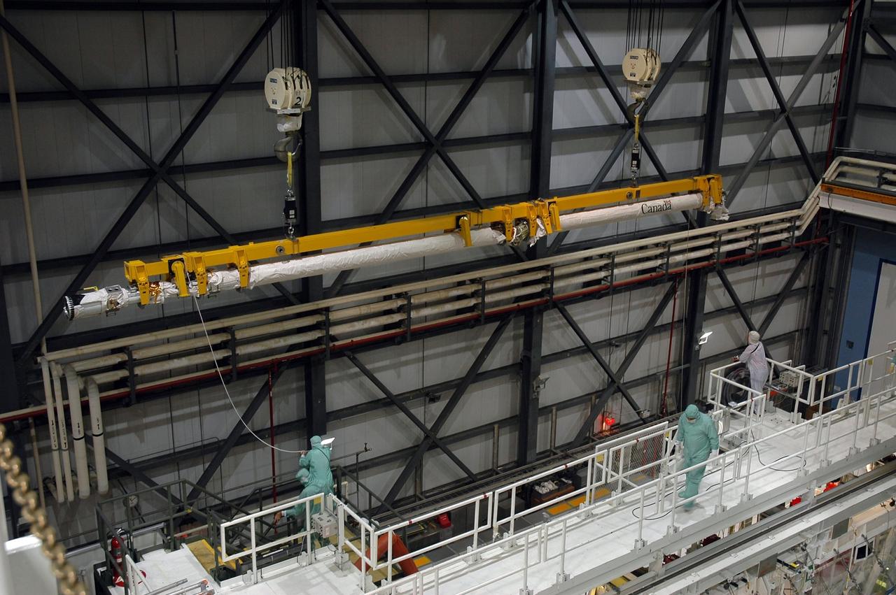 KENNEDY SPACE CENTER, FLA. - In the Orbiter Processing Facility Bay 1 at NASA Kennedy Space Center, the remote manipulator system boom that was removed from Atlantis’ payload bay is lifted out of the way.  The boom will be temporarily stored. The RMS includes the electromechanical arm that maneuvers a payload from the payload bay of the orbiter to its deployment position and then releases it. It can also grapple a free-flying payload, maneuver it to the payload bay of the orbiter and berth it in the orbiter. The RMS arm is 50 feet 3 inches long and 15 inches in diameter. It weighs 905 pounds, and the total system weighs 994 pounds. The RMS has six joints that correspond roughly to the joints of the human arm, with shoulder yaw and pitch joints; an elbow pitch joint; and wrist pitch, yaw and roll joints. The end effector is the unit at the end of the wrist that actually grabs, or grapples, the payload.