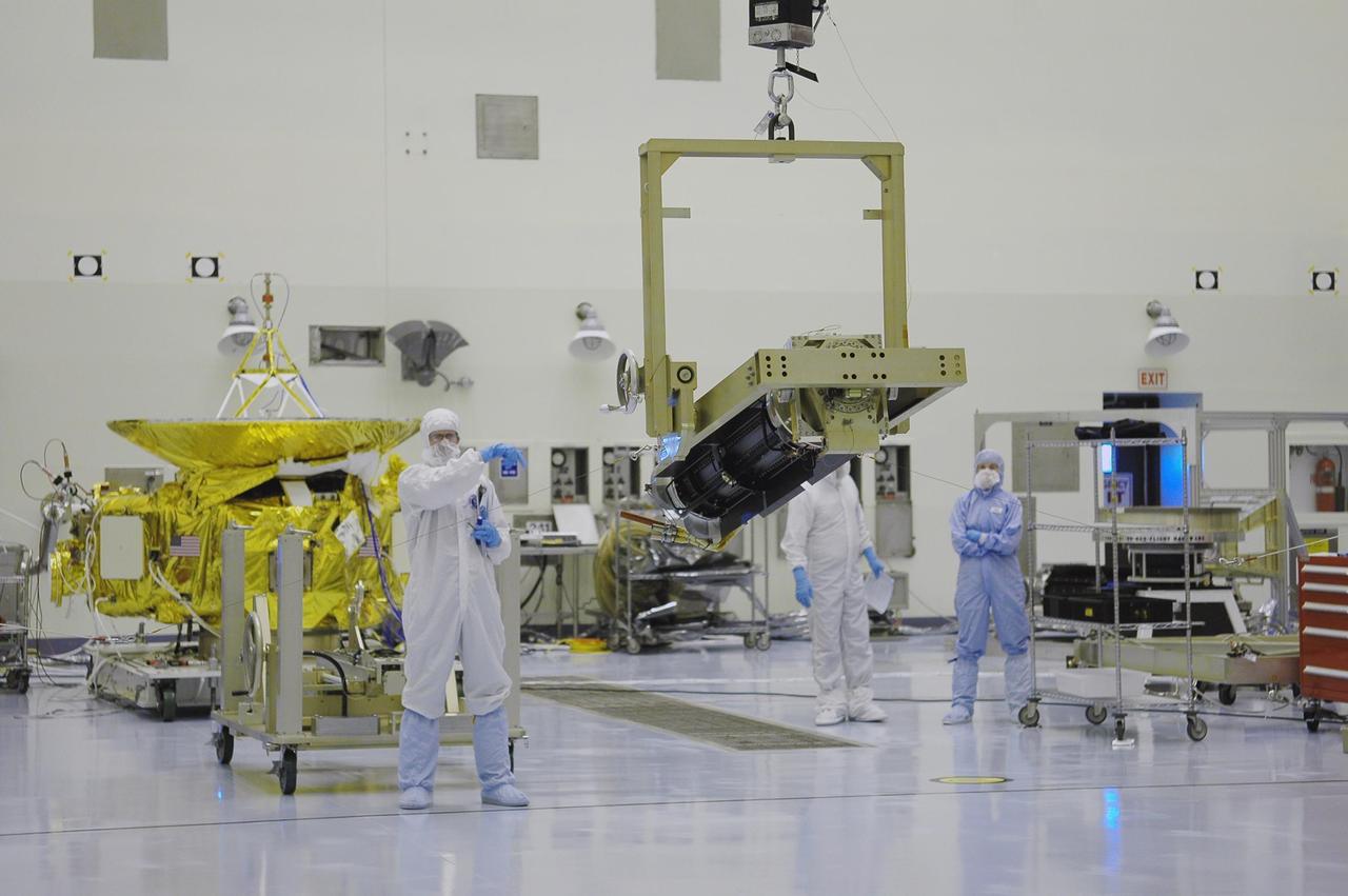 KENNEDY SPACE CENTER, FLA. - Supported by a crane in the Payload Hazardous Servicing Facility, the radioisotope thermoelectric generator (RTG) is rotated to vertical. The RTG is being returned to the RTG facility after completing a fit check with the spacecraft. The RTG is the baseline power supply for the New Horizons, scheduled to launch in January 2006 on a journey to Pluto and its moon, Charon. As it approaches Pluto, the spacecraft will look for ultraviolet emission from Pluto's atmosphere and make the best global maps of Pluto and Charon in green, blue, red and a special wavelength that is sensitive to methane frost on the surface. It will also take spectral maps in the near infrared, telling the science team about Pluto's and Charon's surface compositions and locations and temperatures of these materials. When the spacecraft is closest to Pluto or its moon, it will take close-up pictures in both visible and near-infrared wavelengths. It is expected to reach Pluto in July 2015.