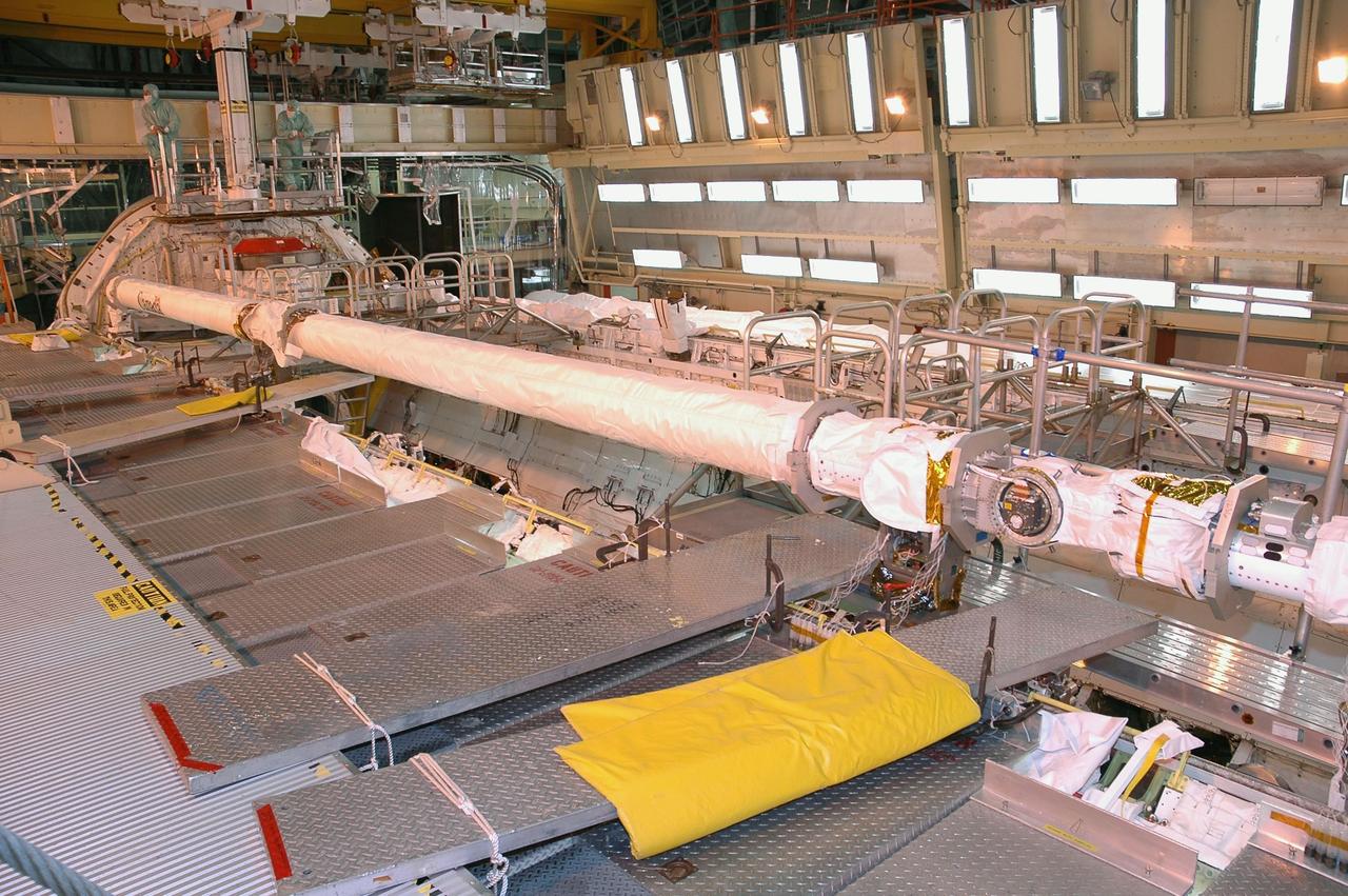 KENNEDY SPACE CENTER, FLA. -  In NASA Kennedy Space Center’s Orbiter Processing Facility Bay 3, a remote manipulator system, or space shuttle arm, previously installed on the orbiter Atlantis, is being installed in Discovery’s payload bay.  The arms were switched because the arm that was installed on Atlantis has special instrumentation to gather loads data from the second return-to-flight mission, STS-121.  Discovery is the designated orbiter to fly on STS-121. scheduled to launch no earlier than May 2006.