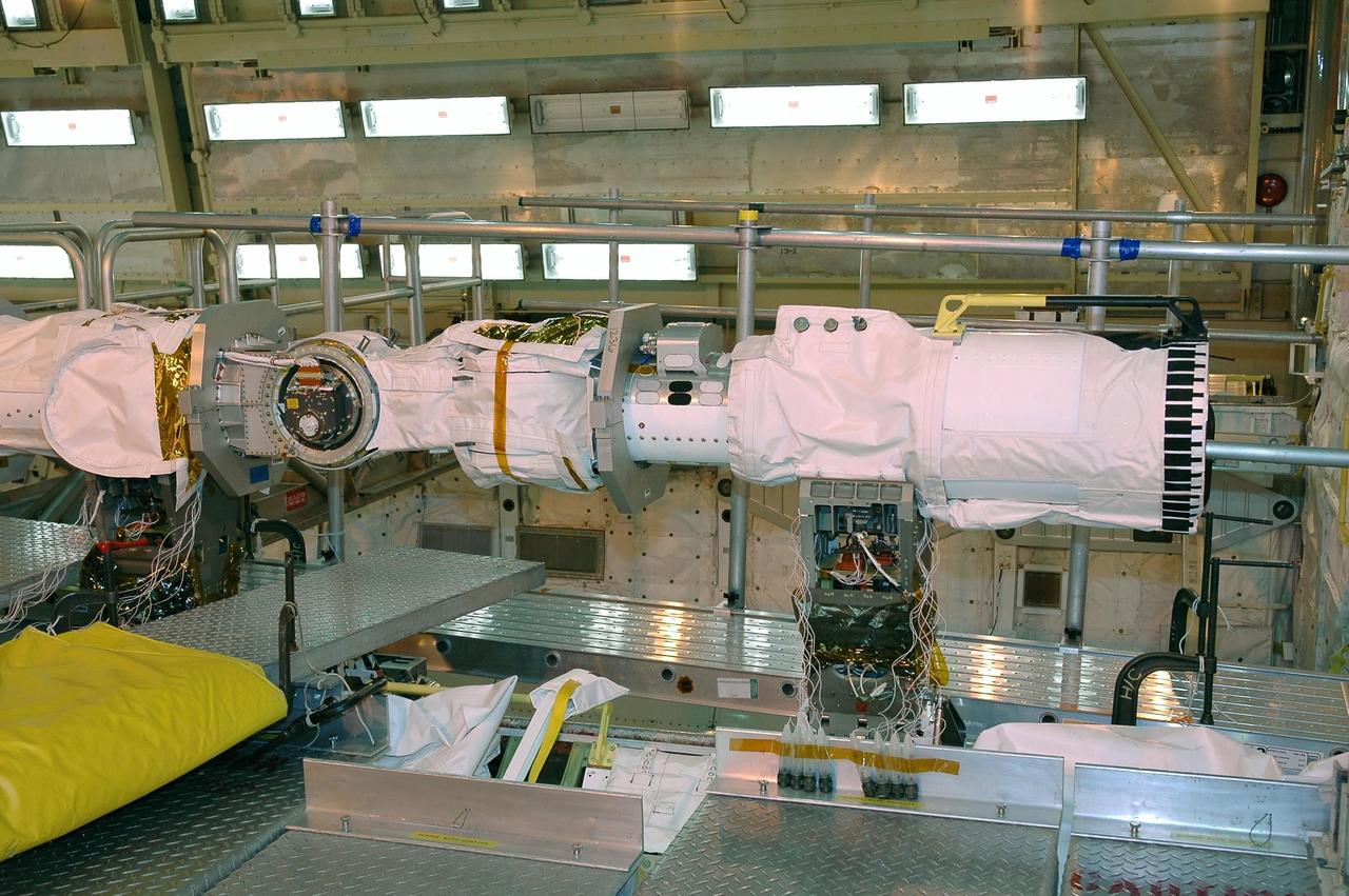 KENNEDY SPACE CENTER, FLA. - In NASA Kennedy Space Center’s Orbiter Processing Facility Bay 3, a remote manipulator system, or space shuttle arm, previously installed on the orbiter Atlantis, is being installed in Discovery’s payload bay. The arms were switched because the arm that was installed on Atlantis has special instrumentation to gather loads data from the second return-to-flight mission, STS-121. Discovery is the designated orbiter to fly on STS-121. scheduled to launch no earlier than May 2006.