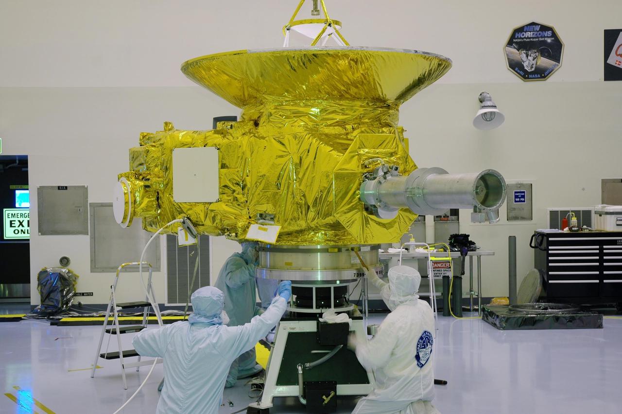 KENNEDY SPACE CENTER, FLA. -In NASA Kennedy Space Center’s Payload Hazardous Servicing Facility, workers secure the New Horizons spacecraft onto a spin table.  The spacecraft will undergo a spin test as part of prelaunch processing.  New Horizons is expected to be launched in January 2006 on a journey to Pluto and its moon, Charon.  It is expected to reach Pluto in July 2015.