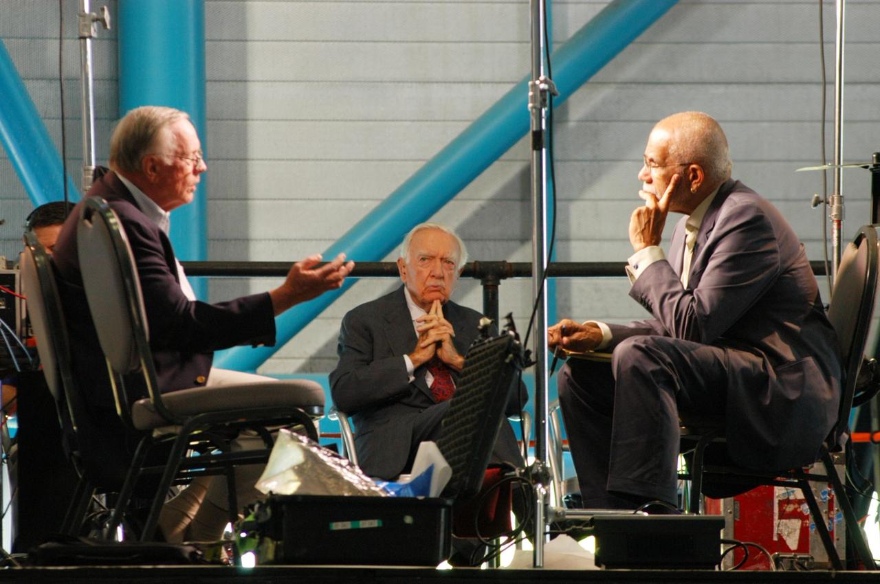 KENNEDY SPACE CENTER, FLA. -   The CBS news program “60 Minutes” is taping a segment inside NASA Kennedy Space Center’s Apollo/Saturn V Center.  Correspondent Ed Bradley (right) is seen here listening intently to former astronaut Neil Armstrong (left), the subject of the interview.  In the background is CBS broadcaster Walter Cronkite, who reunited with Armstrong for the 60 Minutes show. The show aired Nov. 6.