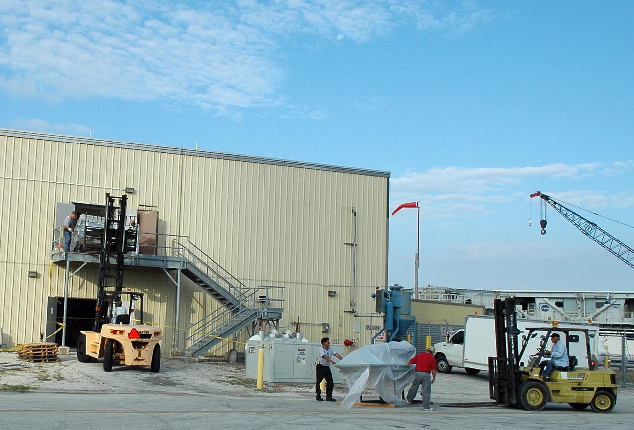 KENNEDY SPACE CENTER, FLA. - Employees at NASA Kennedy Space Center are transferring equipment stored in the RLV Hangar back to the Thermal Protection System (TPS) facility.  The upper floor of the facility, where soft material was processed, was damaged during the 2004 hurricanes.  While the TPS facility was being repaired, normal work activity was done in the hangar.