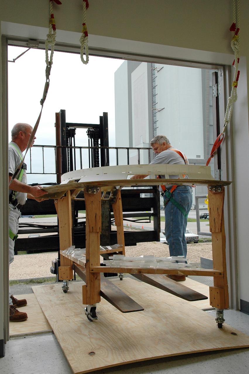 KENNEDY SPACE CENTER, FLA. - Employees at NASA Kennedy Space Center move equipment into the Thermal Protection System facility that has recently been repaired.  The upper floor of the facility, where soft material was processed, was damaged during the 2004 hurricanes and the equipment was temporarily moved to the RLV Hangar.  While the TPS facility was being repaired, normal work activity was done in the hangar.