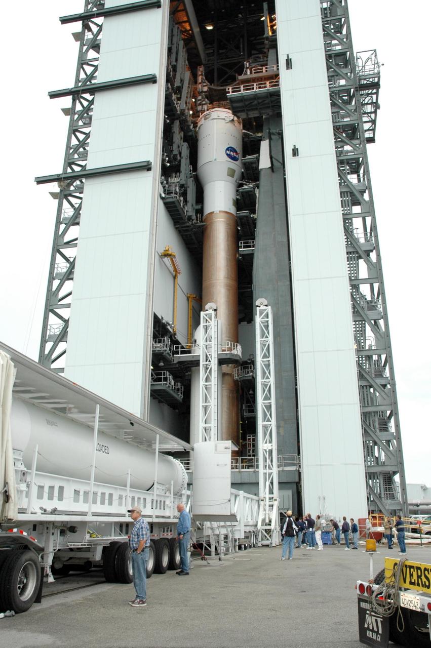 KENNEDY SPACE CENTER, FLA. - The fifth and final solid rocket booster arrives at the Vertical Integration Facility on Launch Complex 41 at Cape Canaveral Air Force Station in Florida. It will be added to the other four already mated to the Lockheed Martin Atlas V rocket, seen in the background. The Atlas V is the launch vehicle for the Pluto-bound New Horizons spacecraft that will make the first reconnaissance of Pluto and its moon, Charon - a "double planet" and the last planet in our solar system to be visited by spacecraft. As it approaches Pluto, the spacecraft will look for ultraviolet emission from Pluto's atmosphere and make the best global maps of Pluto and Charon in green, blue, red and a special wavelength that is sensitive to methane frost on the surface. It will also take spectral maps in the near infrared, telling the science team about Pluto's and Charon’s surface compositions and locations and temperatures of these materials. When the spacecraft is closest to Pluto or its moon, it will take close-up pictures in both visible and near-infrared wavelengths. The mission will then visit one or more objects in the Kuiper Belt region beyond Neptune. New Horizons is scheduled to launch in January 2006, swing past Jupiter for a gravity boost and scientific studies in February or March 2007, and reach Pluto and Charon in July 2015.