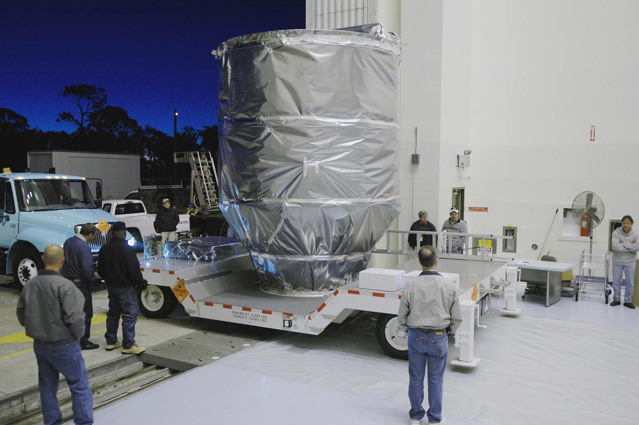 KENNEDY SPACE CENTER, FLA. -   The third stage, or upper stage for the New Horizons spacecraft, is moved toward the open door of NASA Kennedy Space Center’s Payload Hazardous Servicing Facility. The third stage is  a Boeing STAR 48 solid-propellant kick motor.  The Atlas V is the launch vehicle for NASA’s New Horizons spacecraft, scheduled to launch from Cape Canaveral Air Force Station, Fla., during a 35-day window that opens Jan. 11 and fly through the Pluto system as early as summer 2015. New Horizons will be powered by a single radioisotope thermoelectric generator (RTG), provided by the Department of Energy, which will be installed shortly before launch.