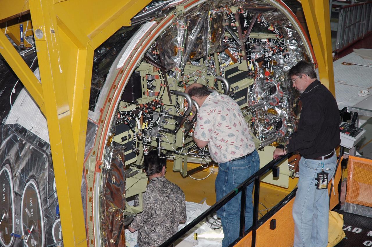 KENNEDY SPACE CENTER, FLA. - In Orbiter Processing Facility Bay 1, technicians work on the Forward Reaction Control System (FRCS) of space shuttle Atlantis as it sits in the transfer aisle prior to installation. The FRCS provides the thrust for attitude (rotational) maneuvers (pitch, yaw and roll) and for small velocity changes along the orbiter axis (translation maneuvers). Processing of Atlantis is under way for mission STS-115, the 19th flight to the International Space Station.