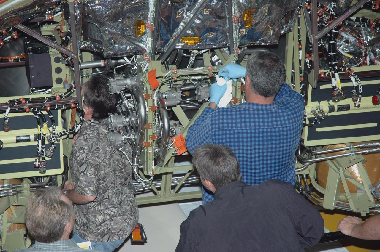 KENNEDY SPACE CENTER, FLA. - In Orbiter Processing Facility Bay 1, technicians work on the Forward Reaction Control System (FRCS) of space shuttle Atlantis as it sits in the transfer aisle prior to installation. The FRCS provides the thrust for attitude (rotational) maneuvers (pitch, yaw and roll) and for small velocity changes along the orbiter axis (translation maneuvers). Processing of Atlantis is under way for mission STS-115, the 19th flight to the International Space Station.