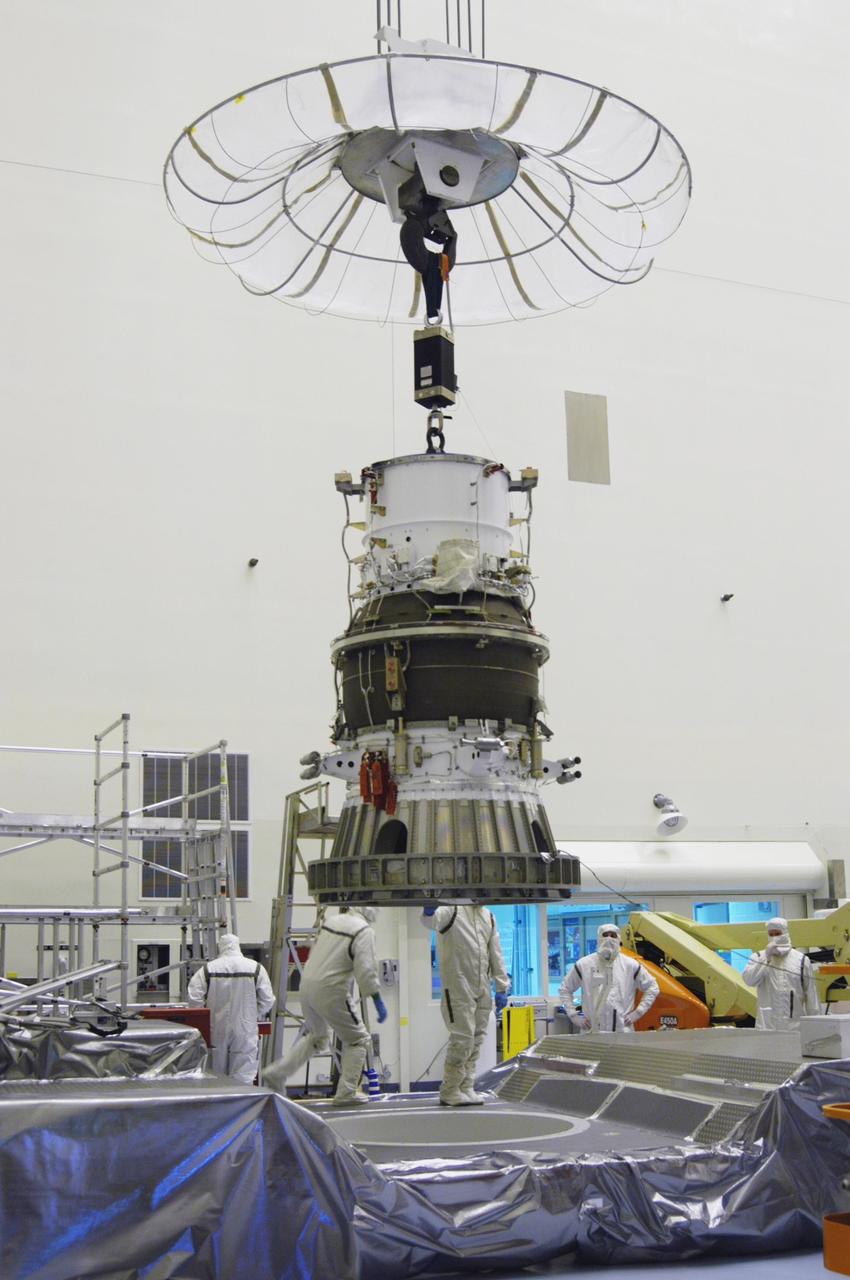 KENNEDY SPACE CENTER, FLA. -   In NASA Kennedy Space Center’s Payload Hazardous Servicing Facility, Boeing workers garbed in clean room suits attach a crane to the third stage, or upper stage for the New Horizons spacecraft.   The third stage, a Boeing STAR 48 solid-propellant kick motor, is being moved to a work stand.  The launch vehicle for New Horizons is the Atlas V rocket, scheduled to launch from Cape Canaveral Air Force Station, Fla., during a 35-day window that opens Jan. 11, and fly through the Pluto system as early as summer 2015.