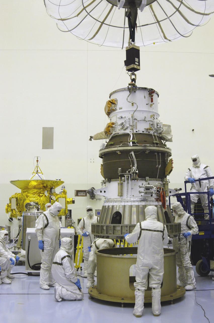 KENNEDY SPACE CENTER, FLA. - In NASA Kennedy Space Center’s Payload Hazardous Servicing Facility, Boeing workers dressed in clean room suits help guide the third, or upper, stage for the New Horizons spacecraft as it is lowered onto a work stand. The launch vehicle for New Horizons is the Atlas V rocket, scheduled to launch from Cape Canaveral Air Force Station, Fla., during a 35-day window that opens Jan. 11, and fly through the Pluto system as early as summer 2015.
