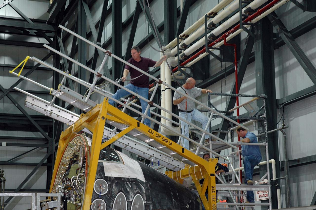 KENNEDY SPACE CENTER, FLA. -- Inside NASA Kennedy Space Center’s Orbiter Processing Facility Bay 1, workers move the sling into place around the forward reaction control system that will be installed on Atlantis. When ready, the shuttle equipment will be lifted for installation. The forward reaction control system is located in the forward fuselage nose area. During ascent of the space shuttle, it provides the thrust for attitude (rotational) maneuvers (pitch, yaw and roll) and for small velocity changes along the orbiter axis (translation maneuvers).