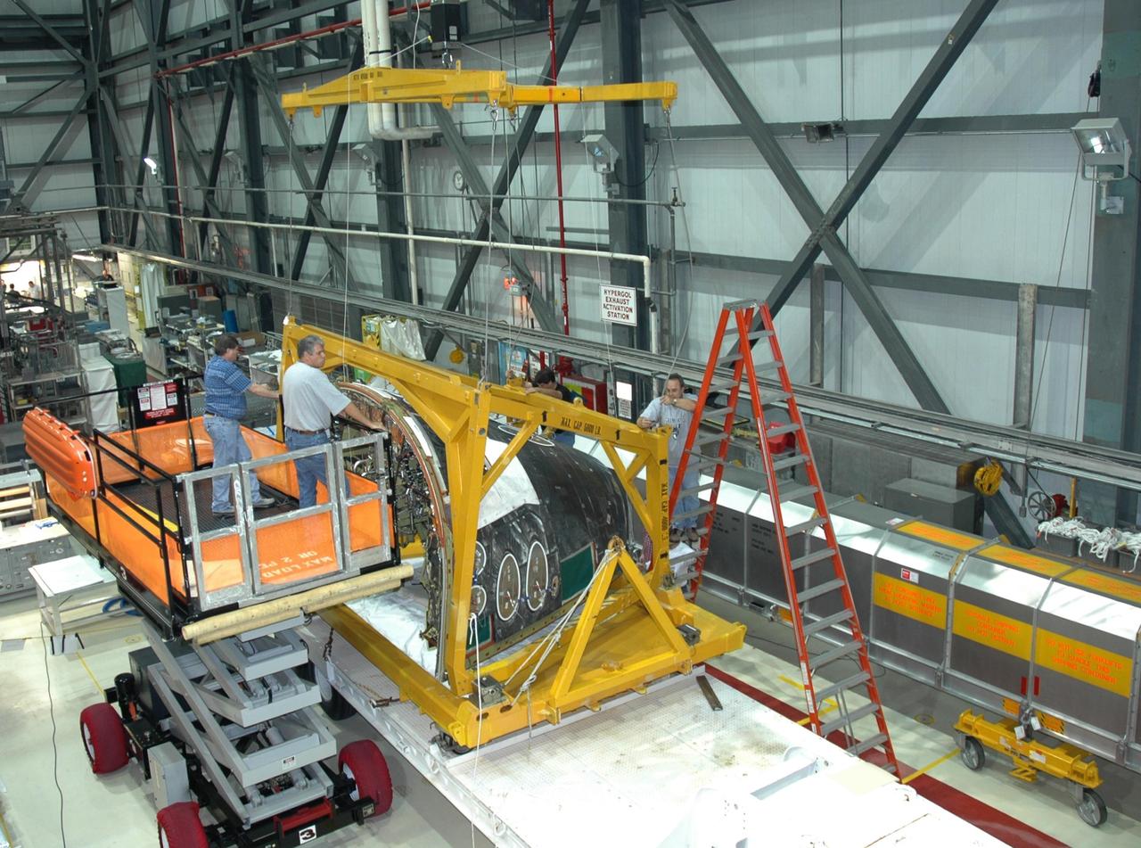 KENNEDY SPACE CENTER, FLA. -- Inside NASA Kennedy Space Center’s Orbiter Processing Facility Bay 1, workers get ready to lift the sling placed round the forward reaction control system that will be installed on Atlantis. The forward reaction control system is located in the forward fuselage nose area. During ascent of the space shuttle, it provides the thrust for attitude (rotational) maneuvers (pitch, yaw and roll) and for small velocity changes along the orbiter axis (translation maneuvers).