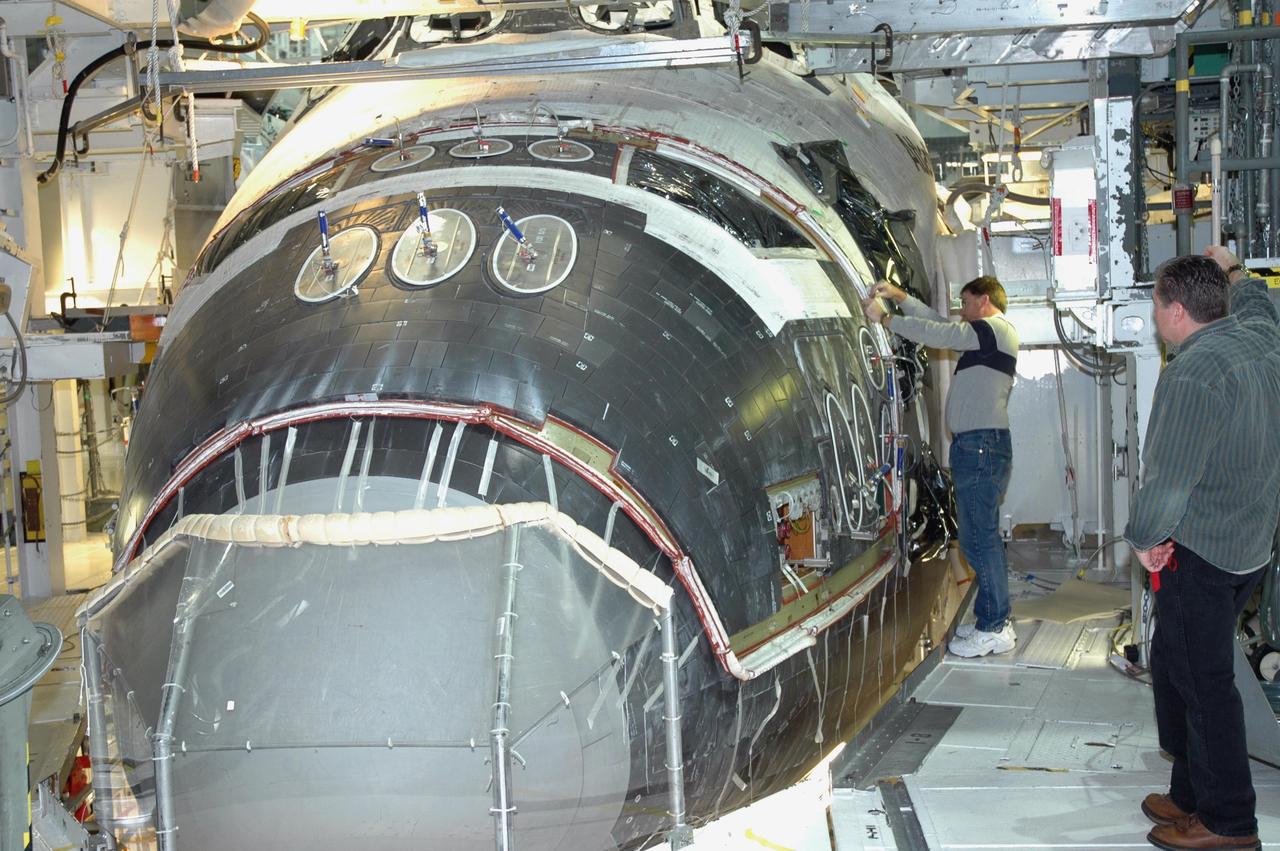 KENNEDY SPACE CENTER, FLA. -- In NASA Kennedy Space Center’s Orbiter Processing Facility Bay 1, workers are installing the forward reaction control system on Atlantis. The control system fits just behind the nose cone and provides the thrust for attitude (rotational) maneuvers (pitch, yaw and roll) and for small velocity changes along the orbiter axis (translation maneuvers). Processing of Atlantis is under way for mission STS-115, the 19th flight to the International Space Station.
