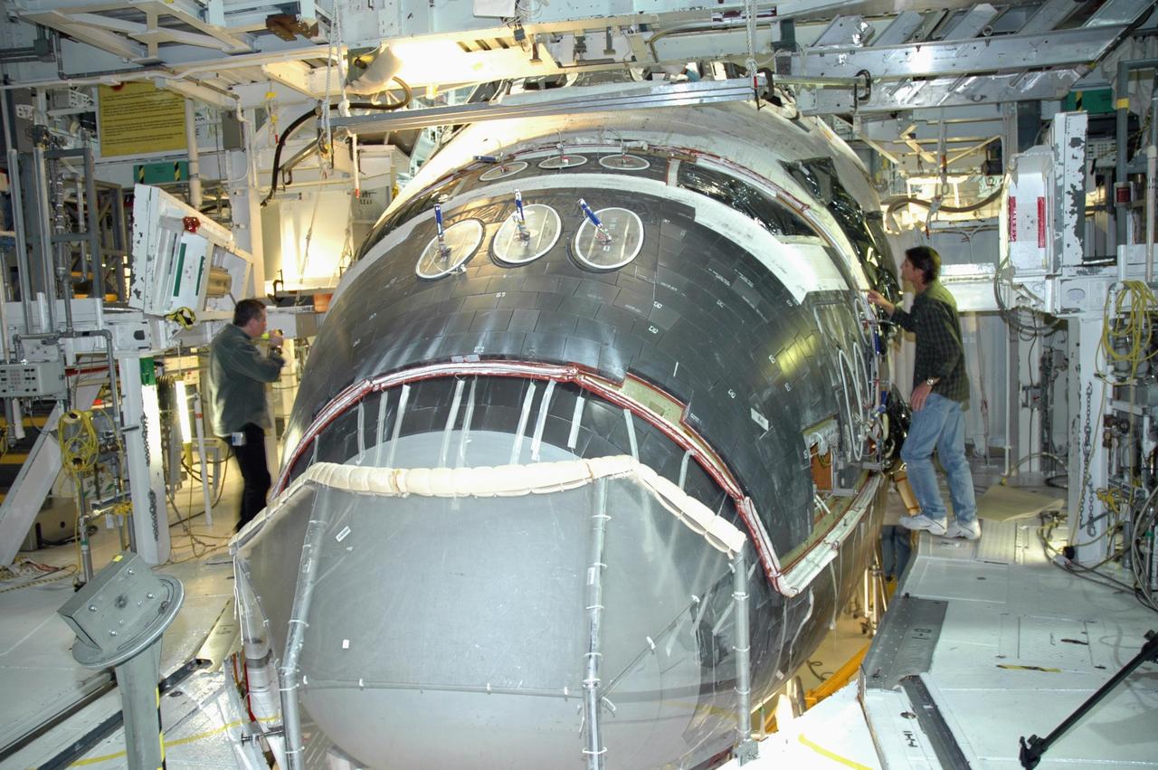 KENNEDY SPACE CENTER, FLA. -- In NASA Kennedy Space Center’s Orbiter Processing Facility Bay 1, workers are installing the forward reaction control system on Atlantis. The control system fits just behind the nose cone and provides the thrust for attitude (rotational) maneuvers (pitch, yaw and roll) and for small velocity changes along the orbiter axis (translation maneuvers). Processing of Atlantis is under way for mission STS-115, the 19th flight to the International Space Station.