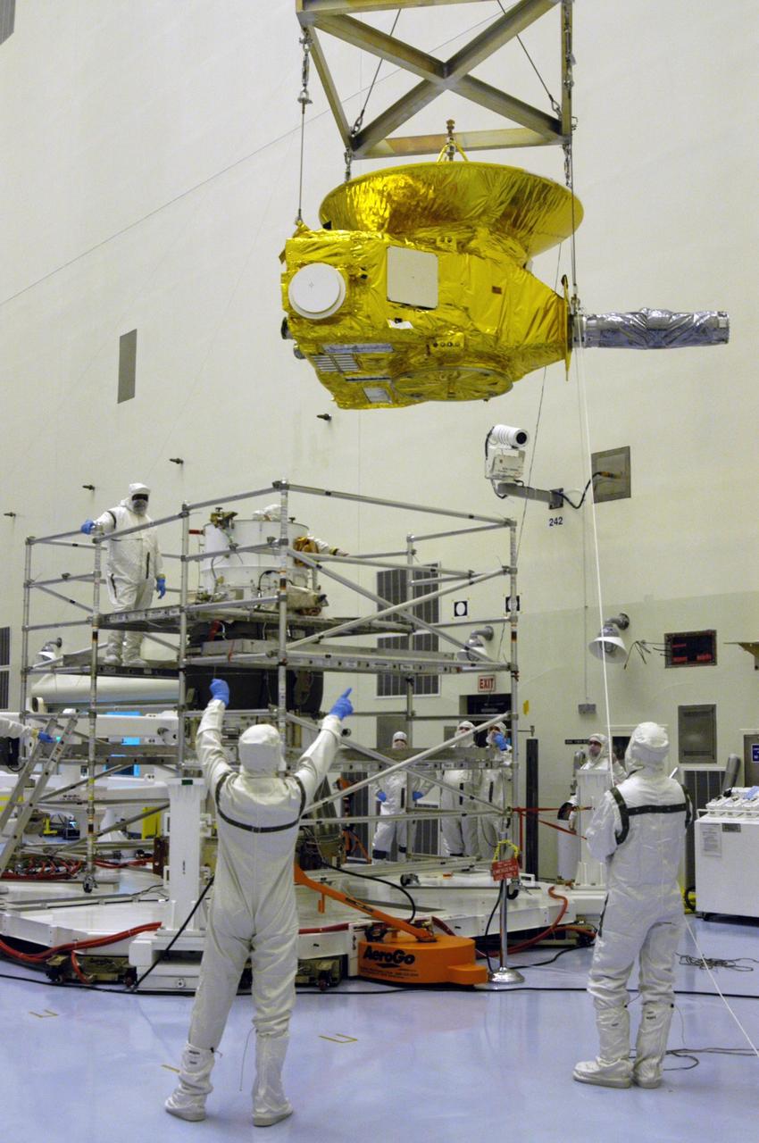 KENNEDY SPACE CENTER, FLA. -- In the Payload Hazardous Servicing Facility at NASA Kennedy Space Center, workers in clean room suits guide the New Horizons spacecraft toward the stand at left with the third stage, or upper booster, a Boeing STAR 48 solid-propellant kick motor. The launch vehicle for New Horizons is the Atlas V rocket, scheduled to launch from Cape Canaveral Air Force Station, Fla., during a 35-day window that opens Jan. 11, and fly through the Pluto system as early as summer 2015.