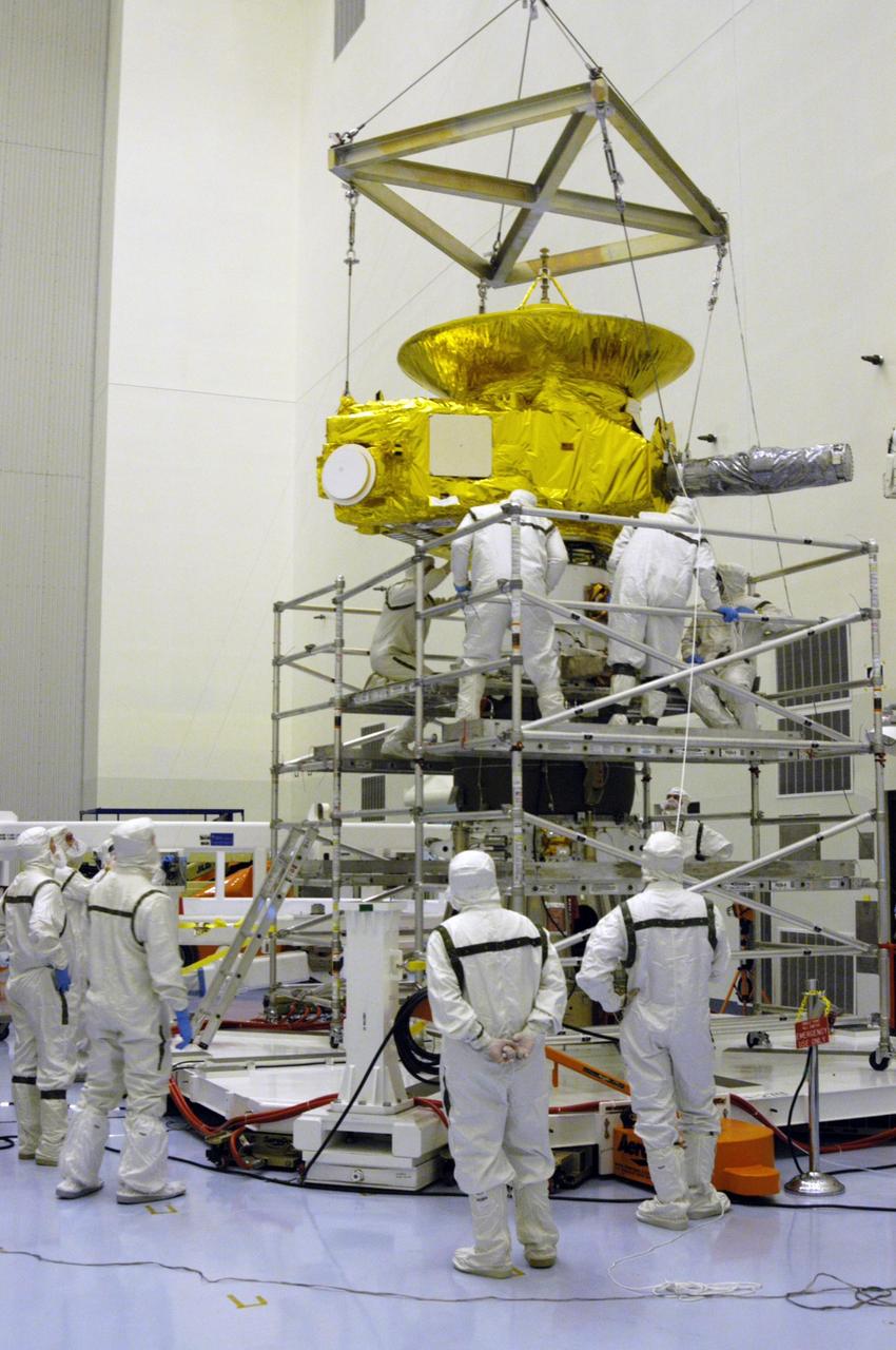 KENNEDY SPACE CENTER, FLA. -- In the Payload Hazardous Servicing Facility at NASA Kennedy Space Center, workers in clean room suits begin mating the New Horizons spacecraft with the third stage, or upper booster, a Boeing STAR 48 solid-propellant kick motor. The launch vehicle for New Horizons is the Atlas V rocket, scheduled to launch from Cape Canaveral Air Force Station, Fla., during a 35-day window that opens Jan. 11, and fly through the Pluto system as early as summer 2015.