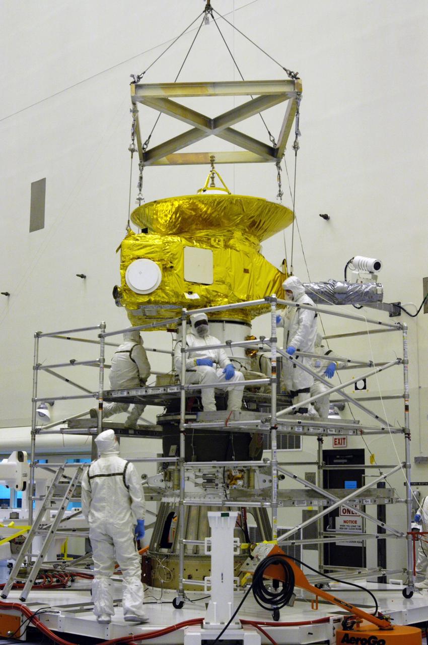 KENNEDY SPACE CENTER, FLA. -- In the Payload Hazardous Servicing Facility at NASA Kennedy Space Center, workers in clean room suits have completed securing the New Horizons spacecraft with the third stage, or upper booster, a Boeing STAR 48 solid-propellant kick motor. The launch vehicle for New Horizons is the Atlas V rocket, scheduled to launch from Cape Canaveral Air Force Station, Fla., during a 35-day window that opens Jan. 11, and fly through the Pluto system as early as summer 2015.