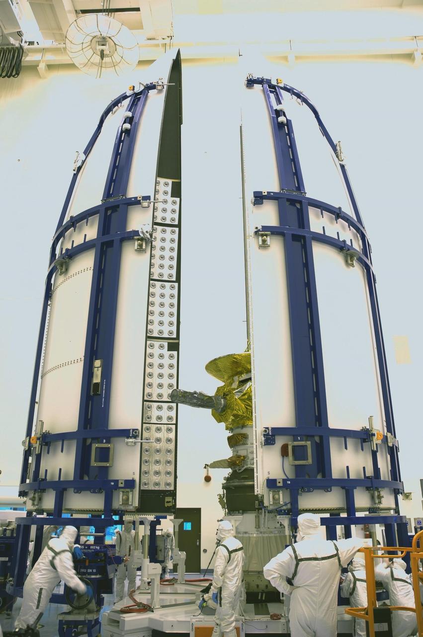 KENNEDY SPACE CENTER, FLA. - In the Payload Hazardous Servicing Facility, the two fairing sections close in around the New Horizons spacecraft to encapsulate it. The fairing protects the spacecraft during launch and flight through the atmosphere. Once out of the atmosphere, the fairing is jettisoned. The compact 1,060-pound New Horizons probe carries seven scientific instruments that will characterize the global geology and geomorphology of Pluto and its moon Charon, map their surface compositions and temperatures, and examine Pluto's complex atmosphere. After that, flybys of Kuiper Belt objects from even farther in the solar system may be undertaken in an extended mission. New Horizons is the first mission in NASA's New Frontiers program of medium-class planetary missions. The spacecraft, designed for NASA by the Johns Hopkins University Applied Physics Laboratory in Laurel, Md., will fly by Pluto and Charon as early as summer 2015.