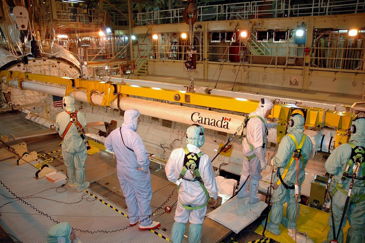 KENNEDY SPACE CENTER, FLA. -- In Orbiter Processing Facility Bay 3, workers install the new orbital boom sensor system in Discovery’s payload bay. The previous boom was removed for repairs on the manipulator positioning mechanism, the pedestals that hold the boom in place in the payload bay. Discovery is the designated orbiter for the second return-to-flight mission, STS-121. The mission is scheduled no earlier than mid-May.