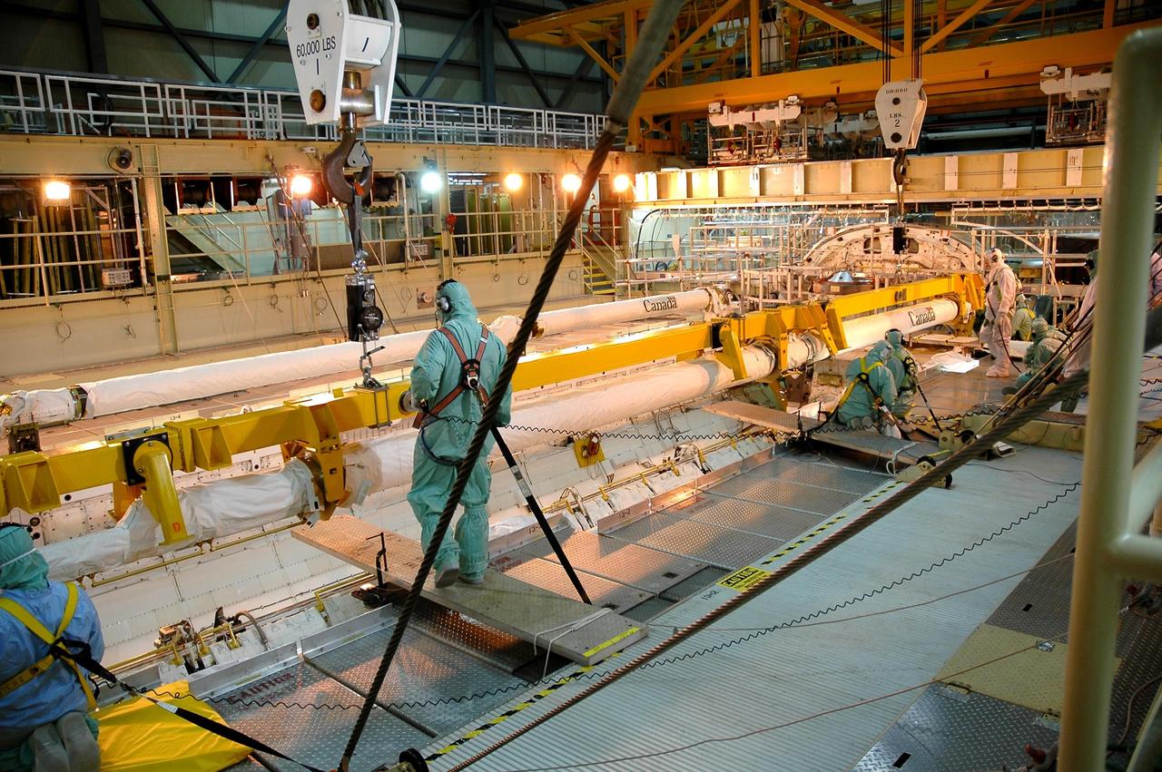 KENNEDY SPACE CENTER, FLA. -- In Orbiter Processing Facility Bay 3, workers check the installation of the new orbital boom sensor system in Discovery’s payload bay. The previous boom was removed for repairs on the manipulator positioning mechanism, the pedestals that hold the boom in place in the payload bay. Discovery is the designated orbiter for the second return-to-flight mission, STS-121. The mission is scheduled no earlier than mid-May.
