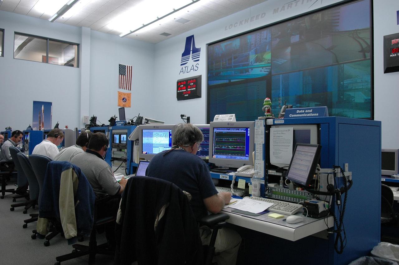 KENNEDY SPACE CENTER, FLA. - At their consoles in the Atlas V Spaceflight Operations Center on Cape Canaveral Air Force Station, members of the New Horizons team take part in a dress rehearsal for the launch scheduled in mid-January. New Horizons carries seven scientific instruments that will characterize the global geology and geomorphology of Pluto and its moon Charon, map their surface compositions and temperatures, and examine Pluto's complex atmosphere. After that, flybys of Kuiper Belt objects from even farther in the solar system may be undertaken in an extended mission. New Horizons is the first mission in NASA's New Frontiers program of medium-class planetary missions. The spacecraft, designed for NASA by the Johns Hopkins University Applied Physics Laboratory in Laurel, Md., will launch aboard a Lockheed Martin Atlas V rocket and fly by Pluto and Charon as early as summer 2015.