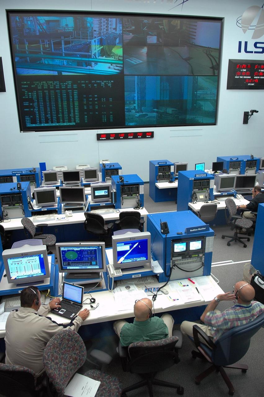 KENNEDY SPACE CENTER, FLA. - At their consoles in the Atlas V Spaceflight Operations Center on Cape Canaveral Air Force Station, members of the New Horizons team take part in a dress rehearsal for the launch scheduled in mid-January. New Horizons carries seven scientific instruments that will characterize the global geology and geomorphology of Pluto and its moon Charon, map their surface compositions and temperatures, and examine Pluto's complex atmosphere. After that, flybys of Kuiper Belt objects from even farther in the solar system may be undertaken in an extended mission. New Horizons is the first mission in NASA's New Frontiers program of medium-class planetary missions. The spacecraft, designed for NASA by the Johns Hopkins University Applied Physics Laboratory in Laurel, Md., will launch aboard a Lockheed Martin Atlas V rocket and fly by Pluto and Charon as early as summer 2015.