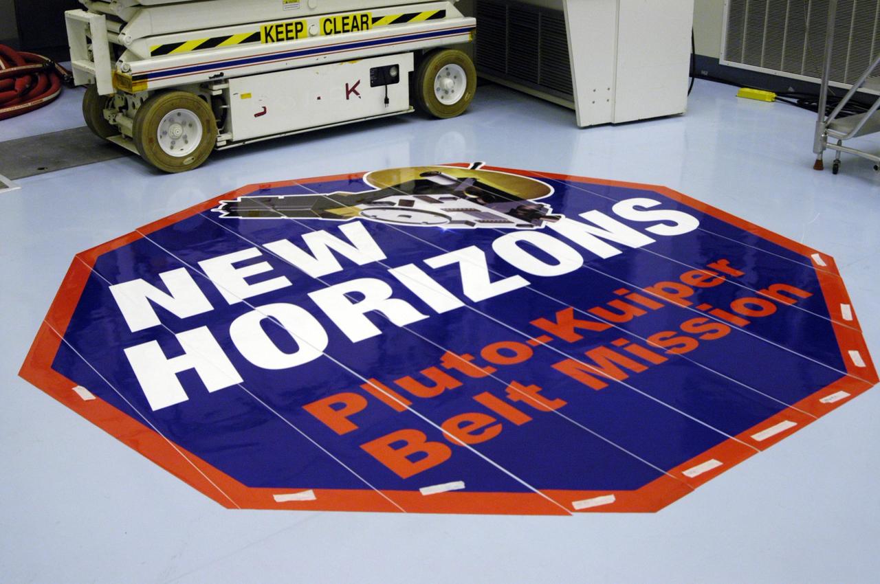 KENNEDY SPACE CENTER, FLA. - The mission decal for New Horizons is laid out in strips on the floor of the Payload Hazardous Servicing Facility before installation onto the spacecraft's fairing. New Horizons carries seven scientific instruments that will characterize the global geology and geomorphology of Pluto and its moon Charon, map their surface compositions and temperatures, and examine Pluto's complex atmosphere. After that, flybys of Kuiper Belt objects from even farther in the solar system may be undertaken in an extended mission. New Horizons is the first mission in NASA's New Frontiers program of medium-class planetary missions. The spacecraft, designed for NASA by the Johns Hopkins University Applied Physics Laboratory in Laurel, Md., will launch aboard a Lockheed Martin Atlas V rocket and fly by Pluto and Charon as early as summer 2015.