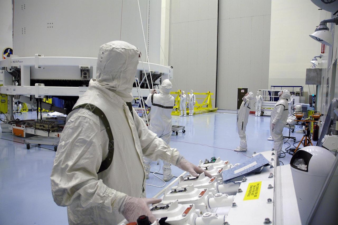 KENNEDY SPACE CENTER, FLA. - In the Payload Hazardous Servicing Facility, technicians prepare to lift New Horizons to a transporter for its move to Complex 41 on Cape Canaveral Air Force Station. New Horizons carries seven scientific instruments that will characterize the global geology and geomorphology of Pluto and its moon Charon, map their surface compositions and temperatures, and examine Pluto's complex atmosphere. After that, flybys of Kuiper Belt objects from even farther in the solar system may be undertaken in an extended mission. New Horizons is the first mission in NASA's New Frontiers program of medium-class planetary missions. The spacecraft, designed for NASA by the Johns Hopkins University Applied Physics Laboratory in Laurel, Md., will launch aboard a Lockheed Martin Atlas V rocket and fly by Pluto and Charon as early as summer 2015.
