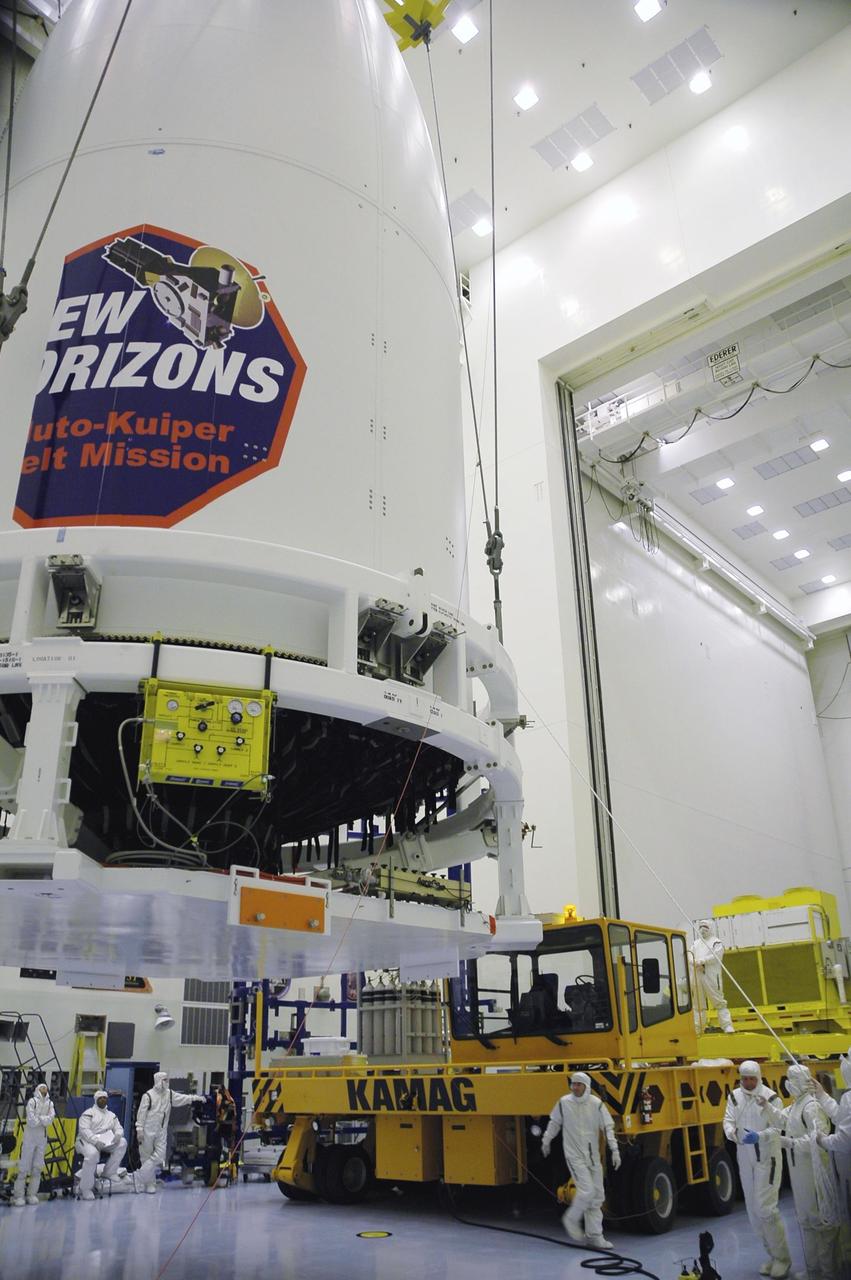 KENNEDY SPACE CENTER, FLA. - In the Payload Hazardous Servicing Facility, technicians lift New Horizons toward a transporter for its move to Complex 41 on Cape Canaveral Air Force Station. The last strip of the mission decal will be installed on the fairing after the spacecraft is delivered to the pad. New Horizons carries seven scientific instruments that will characterize the global geology and geomorphology of Pluto and its moon Charon, map their surface compositions and temperatures, and examine Pluto's complex atmosphere. After that, flybys of Kuiper Belt objects from even farther in the solar system may be undertaken in an extended mission. New Horizons is the first mission in NASA's New Frontiers program of medium-class planetary missions. The spacecraft, designed for NASA by the Johns Hopkins University Applied Physics Laboratory in Laurel, Md., will launch aboard a Lockheed Martin Atlas V rocket and fly by Pluto and Charon as early as summer 2015.