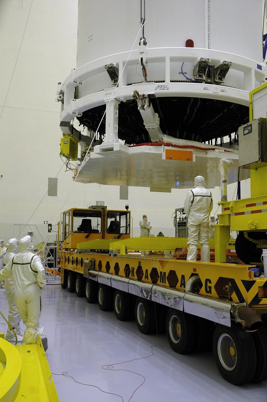 KENNEDY SPACE CENTER, FLA. - In the Payload Hazardous Servicing Facility, technicians monitor New Horizons as it is lowered onto a transporter for its move to Complex 41 on Cape Canaveral Air Force Station. New Horizons carries seven scientific instruments that will characterize the global geology and geomorphology of Pluto and its moon Charon, map their surface compositions and temperatures, and examine Pluto's complex atmosphere. After that, flybys of Kuiper Belt objects from even farther in the solar system may be undertaken in an extended mission. New Horizons is the first mission in NASA's New Frontiers program of medium-class planetary missions. The spacecraft, designed for NASA by the Johns Hopkins University Applied Physics Laboratory in Laurel, Md., will launch aboard a Lockheed Martin Atlas V rocket and fly by Pluto and Charon as early as summer 2015.