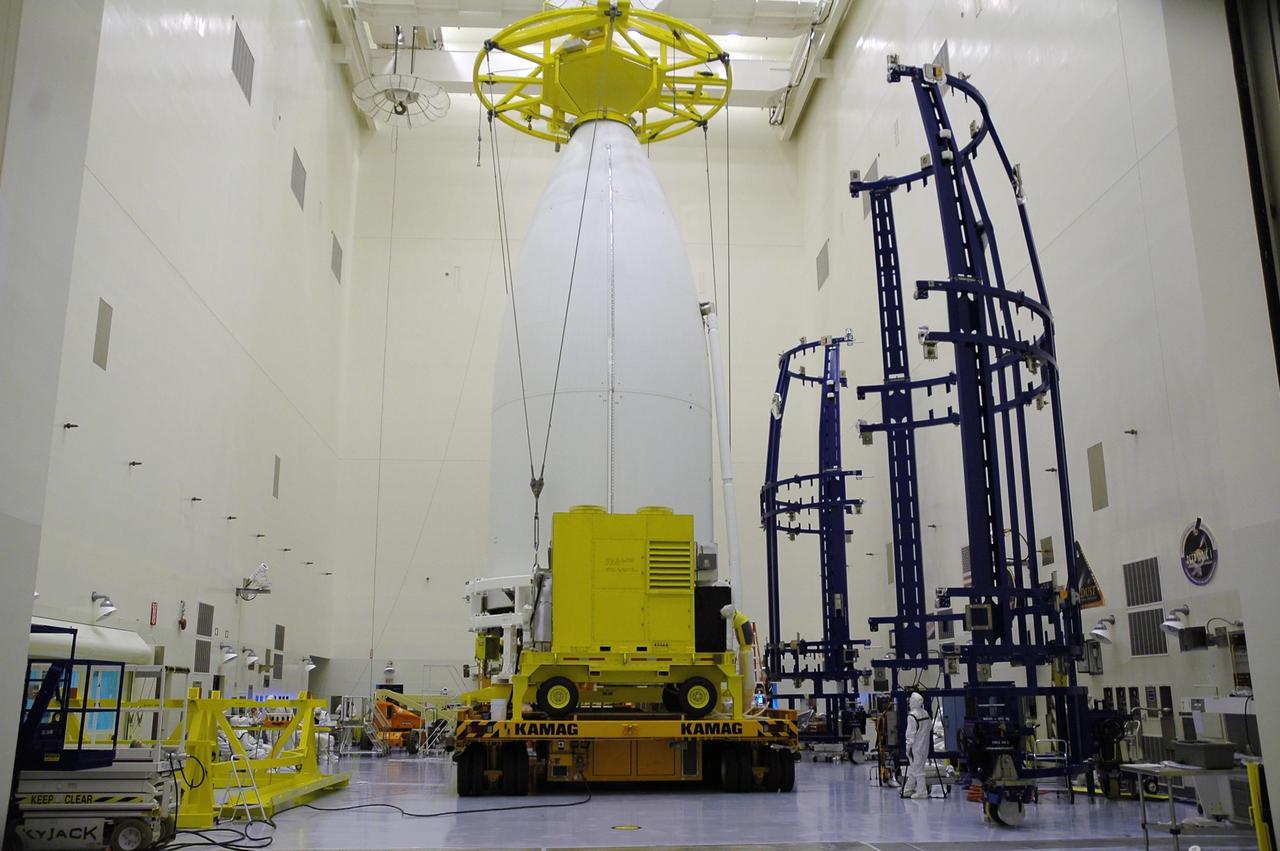 KENNEDY SPACE CENTER, FLA. - In the Payload Hazardous Servicing Facility, New Horizons sits atop a transporter awaiting its move to Complex 41 on Cape Canaveral Air Force Station. New Horizons carries seven scientific instruments that will characterize the global geology and geomorphology of Pluto and its moon Charon, map their surface compositions and temperatures, and examine Pluto's complex atmosphere. After that, flybys of Kuiper Belt objects from even farther in the solar system may be undertaken in an extended mission. New Horizons is the first mission in NASA's New Frontiers program of medium-class planetary missions. The spacecraft, designed for NASA by the Johns Hopkins University Applied Physics Laboratory in Laurel, Md., will launch aboard a Lockheed Martin Atlas V rocket and fly by Pluto and Charon as early as summer 2015.