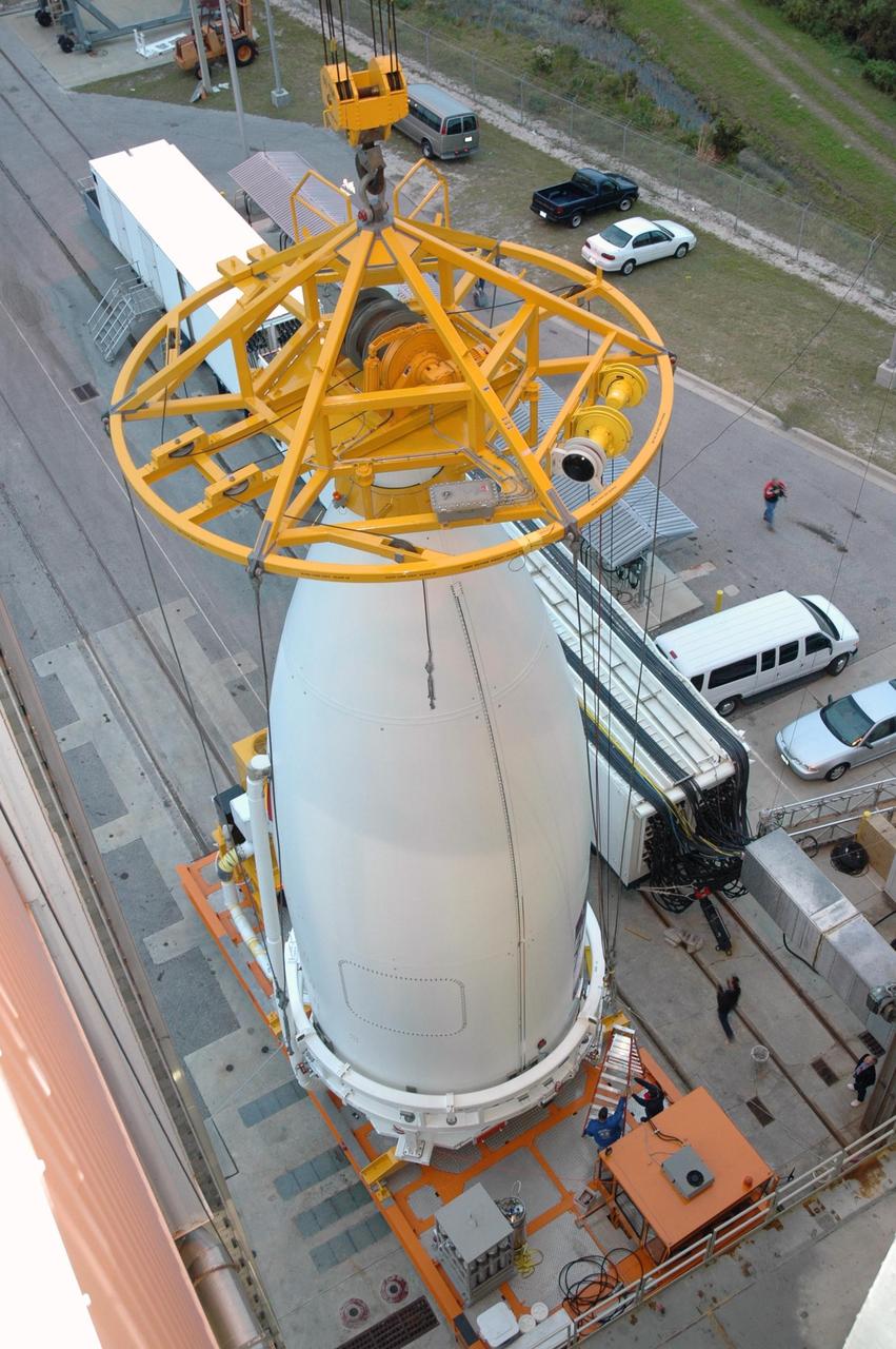 KENNEDY SPACE CENTER, FLA. - The fairing lifting fixture is secured to the nose of the fairing enclosing New Horizons at the Vertical Integration Facility at Complex 41 on Cape Canaveral Air Force Station. New Horizons carries seven scientific instruments that will characterize the global geology and geomorphology of Pluto and its moon Charon, map their surface compositions and temperatures, and examine Pluto's complex atmosphere. After that, flybys of Kuiper Belt objects from even farther in the solar system may be undertaken in an extended mission. New Horizons is the first mission in NASA's New Frontiers program of medium-class planetary missions. The spacecraft, designed for NASA by the Johns Hopkins University Applied Physics Laboratory in Laurel, Md., will launch aboard a Lockheed Martin Atlas V rocket and fly by Pluto and Charon as early as summer 2015.