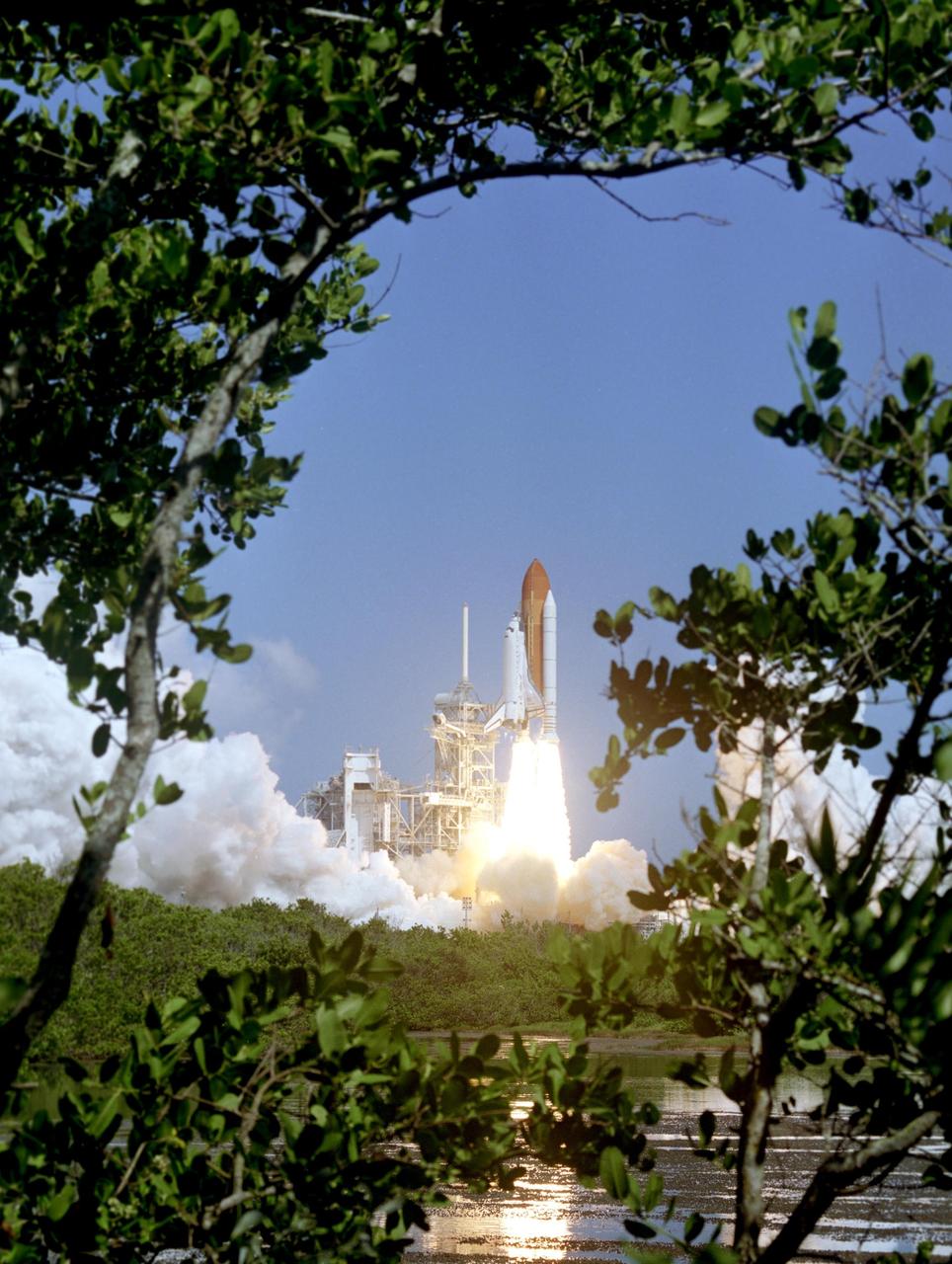 KENNEDY SPACE CENTER, FLA. - Framed by Florida greenery, Space Shuttle Discovery lifts off Launch Pad 39B at 10:39 a.m. EDT on the historic Return to Flight mission STS-114.  It is the 114th Space Shuttle flight and the 31st for Discovery.  The 12-day mission is expected to end with touchdown at the Shuttle Landing Facility on Aug. 7.  On this mission to the International Space Station the crew will perform inspections on-orbit for the first time of all of the Reinforced Carbon-Carbon (RCC) panels on the leading edge of the wings and the Thermal Protection System tiles using the new Canadian-built Orbiter Boom Sensor System and the data from 176 impact and temperature sensors. Mission Specialists will also practice repair techniques on RCC and tile samples during a spacewalk in the payload bay.  During two additional spacewalks, the crew will install the External Stowage Platform-2, equipped with spare part assemblies, and a replacement Control Moment Gyroscope contained in the Lightweight Multi-Purpose Experiment Support Structure.