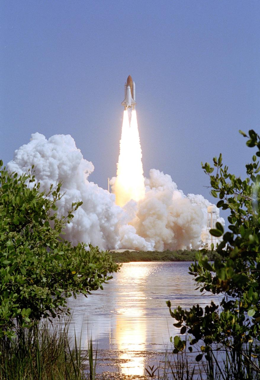 KENNEDY SPACE CENTER, FLA. - The flames of Space Shuttle Discovery’s Solid Rocket Boosters are reflected in the water next to Launch Pad 39B as the Shuttle leaps from the pad on the historic Return to Flight mission STS-114. Liftoff occurred at 10:39 a.m. EDT. It is the 114th Space Shuttle flight and the 31st for Discovery. The 12-day mission is expected to end with touchdown at the Shuttle Landing Facility on Aug. 7. On this mission to the International Space Station the crew will perform inspections on-orbit for the first time of all of the Reinforced Carbon-Carbon (RCC) panels on the leading edge of the wings and the Thermal Protection System tiles using the new Canadian-built Orbiter Boom Sensor System and the data from 176 impact and temperature sensors. Mission Specialists will also practice repair techniques on RCC and tile samples during a spacewalk in the payload bay. During two additional spacewalks, the crew will install the External Stowage Platform-2, equipped with spare part assemblies, and a replacement Control Moment Gyroscope contained in the Lightweight Multi-Purpose Experiment Support Structure.
