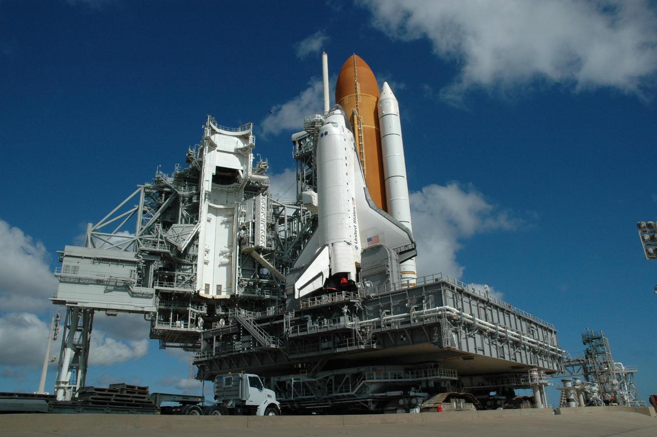 KENNEDY SPACE CENTER, FLA. - The crawler-transporter underneath Space Shuttle Atlantis and mobile launcher platform begins rolling away from Launch Pad 39B, taking the shuttle back to the Vehicle Assembly Building. The rollback is a safety precaution as the area waits for the arrival of Tropical Storm Ernesto. The storm is forecast to be bringing 58-mph to 70-mph winds in the next 24 hours. The shuttle will be moved into high bay 2, on the southwest side of the VAB, for protection from the storm. Photo credit: NASA/Jack Pfaller