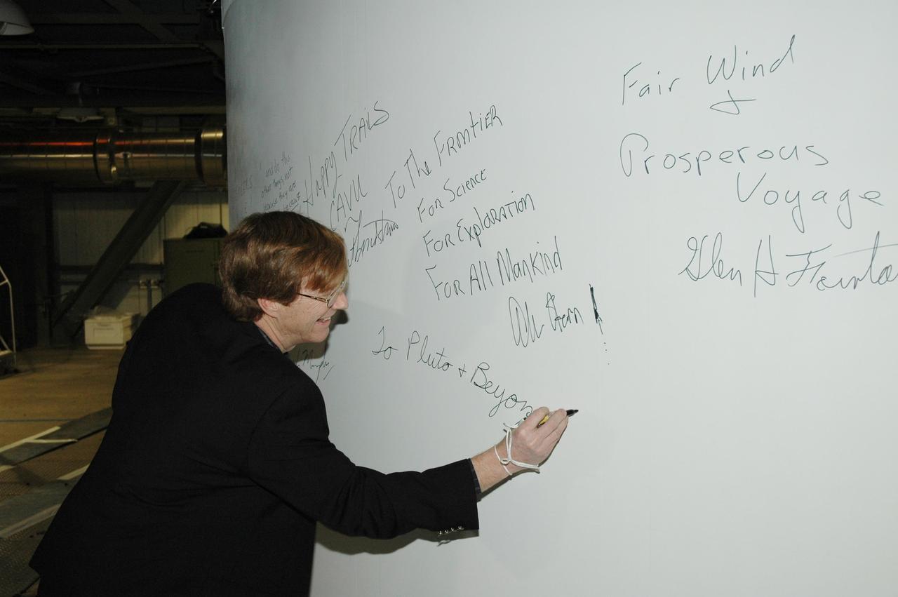 KENNEDY SPACE CENTER, FLA. - In the Vertical Integration Facility on Launch Complex 41, Cape Canaveral Air Force Station, Hal Weaver, New Horizons project scientist with the Johns Hopkins University Applied Physics Laboratory, signs the fairing enclosing the New Horizons spacecraft. The fairing protects the spacecraft during launch and flight through the atmosphere. Once out of the atmosphere, the fairing is jettisoned. The compact 1,060-pound New Horizons probe carries seven scientific instruments that will characterize the global geology and geomorphology of Pluto and its moon Charon, map their surface compositions and temperatures, and examine Pluto's complex atmosphere. New Horizons is the first mission in NASA's New Frontiers program of medium-class planetary missions. The spacecraft, designed for NASA by the Johns Hopkins University Applied Physics Laboratory in Laurel, Md., will fly by Pluto and Charon as early as summer 2015.
