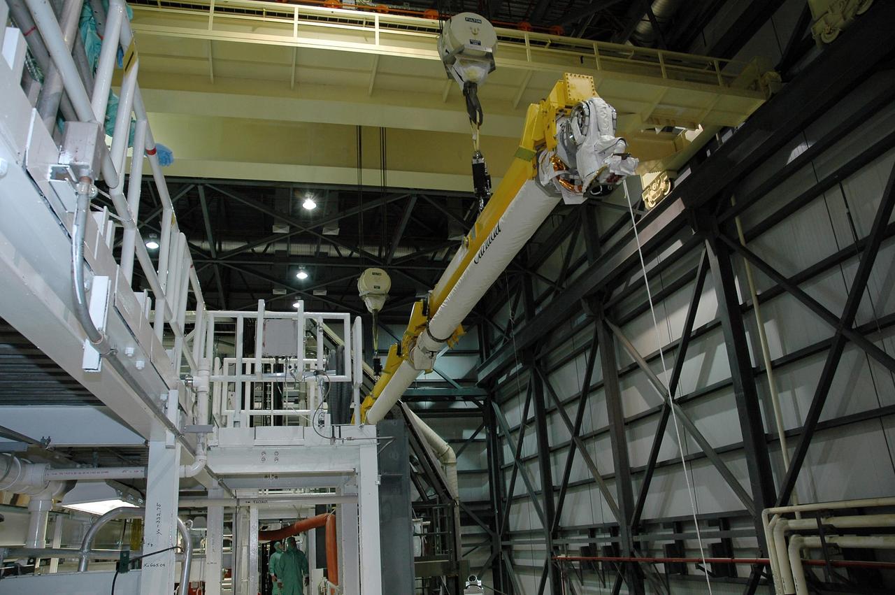 KENNEDY SPACE CENTER, FLA. -   In the Orbiter Processing Facility bay 1 at NASA Kennedy Space Center, overhead cranes lift the remote manipulator system, or boom, to move it to Atlantis’ payload bay for installation. Atlantis is the designated orbiter for mission STS-115, the 19th assembly flight to the International Space Station.  The payload includes the P3/P4 solar arrays. The launch planning window has not been determined yet for STS-115.