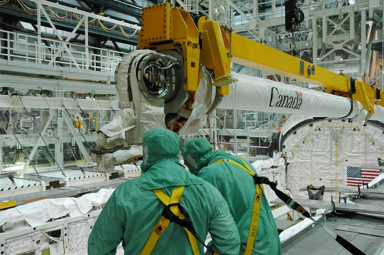 KENNEDY SPACE CENTER, FLA. -  In the Orbiter Processing Facility bay 1 at NASA Kennedy Space Center, the remote manipulator system, or boom, is lowered into Atlantis’ payload bay for installation.  Atlantis is the designated orbiter for mission STS-115, the 19th assembly flight to the International Space Station.  The payload includes the P3/P4 solar arrays. The launch planning window has not been determined yet for STS-115.